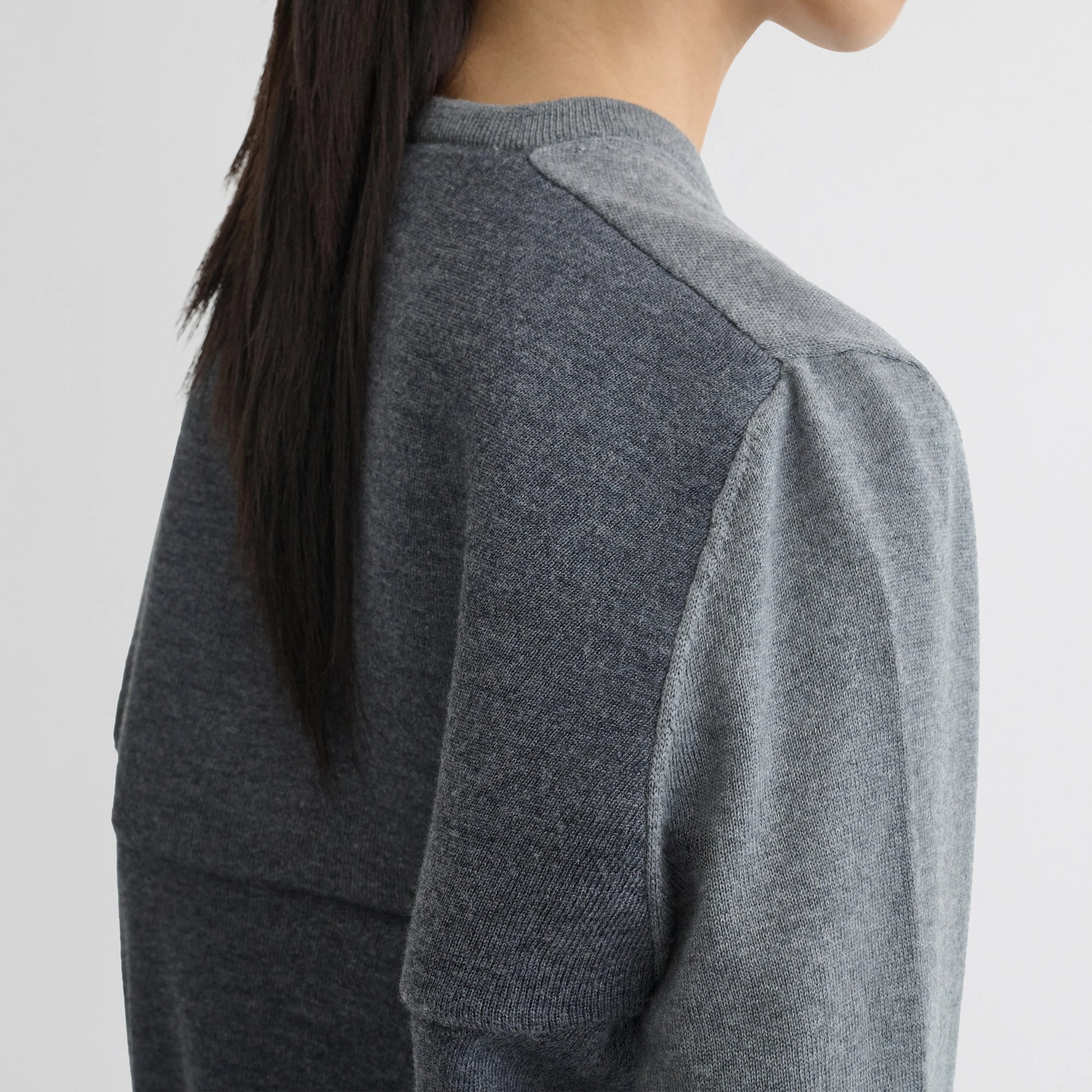 Close up detail view of backed v-neck sweater in light grey wool.