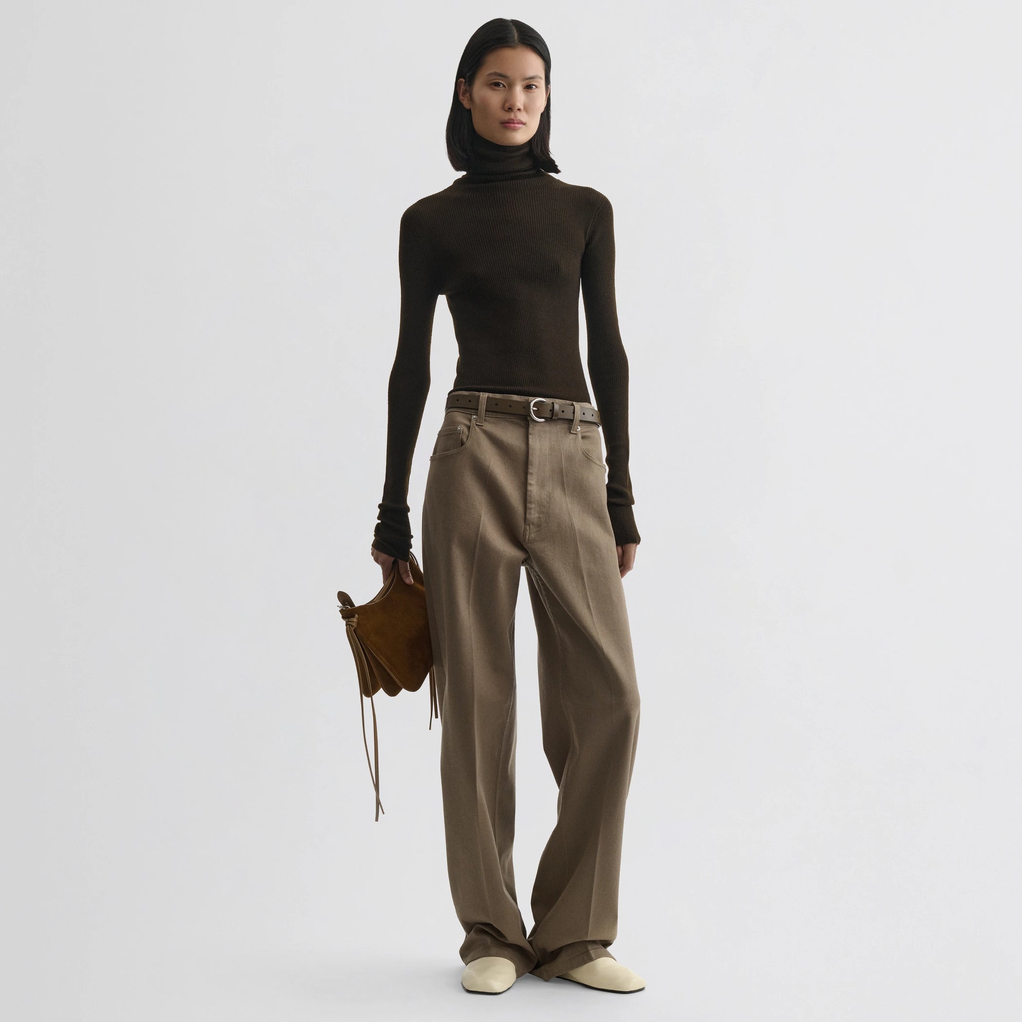Front view of model wearing fine rib high neck top in dark khaki wool.