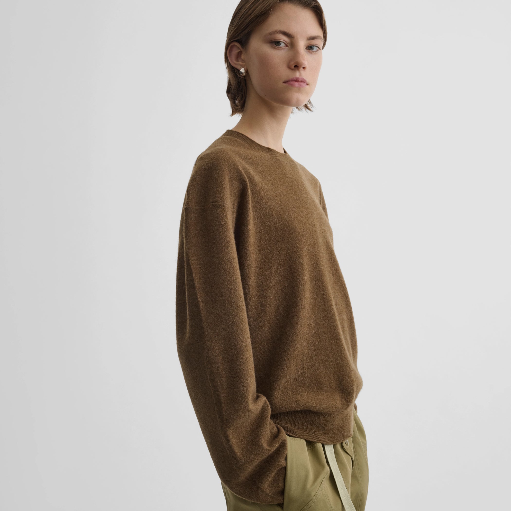 Side view of model wearing dropped shoulder jumper in tobacco melange cashmere