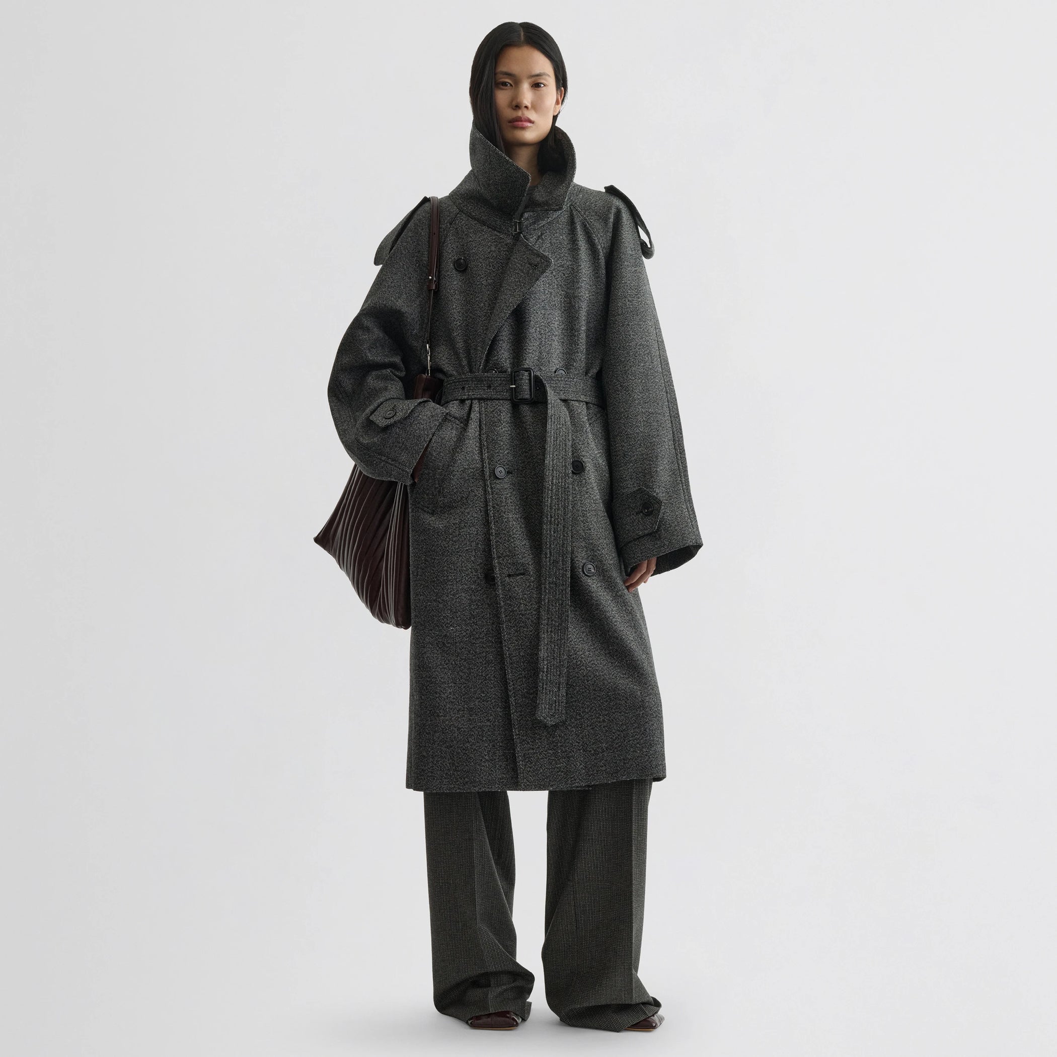 Front view of model wearing padded trench coat in salt and pepper wool.