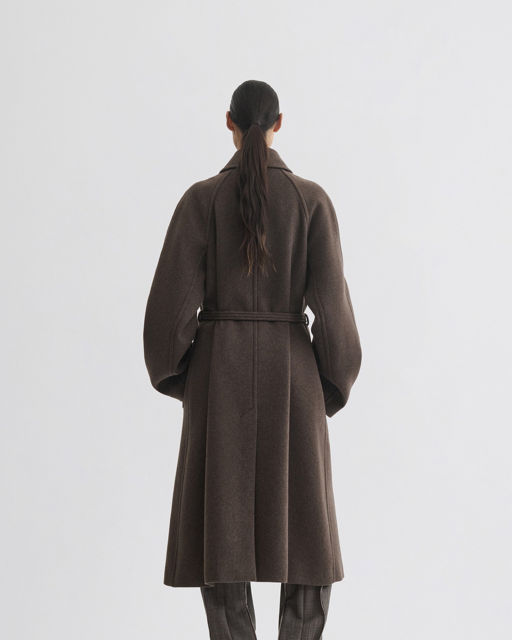 Back view of model wearing curve shoulder coat in brown cashmere.
