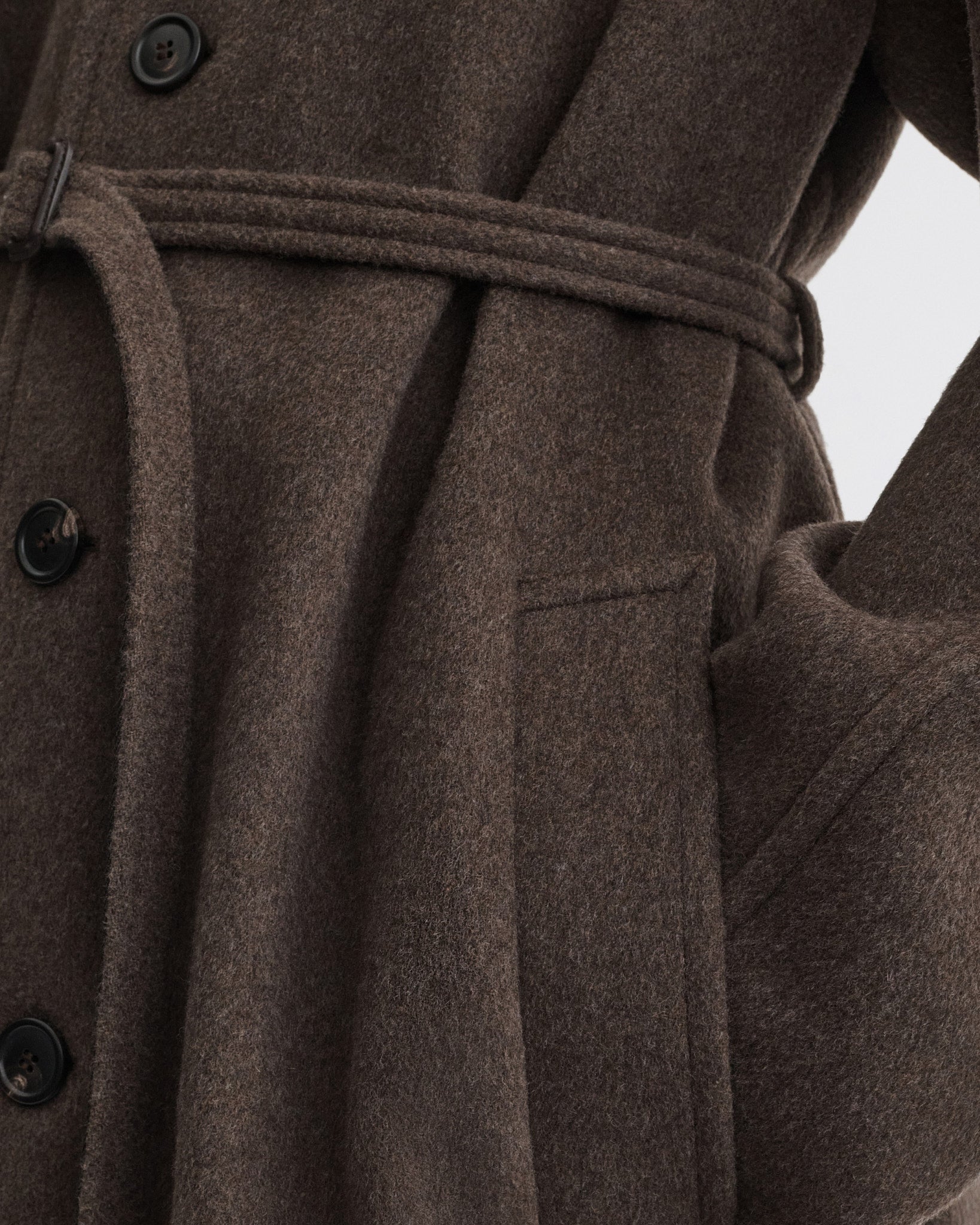 Close up detail view of curve shoulder coat in brown cashmere.