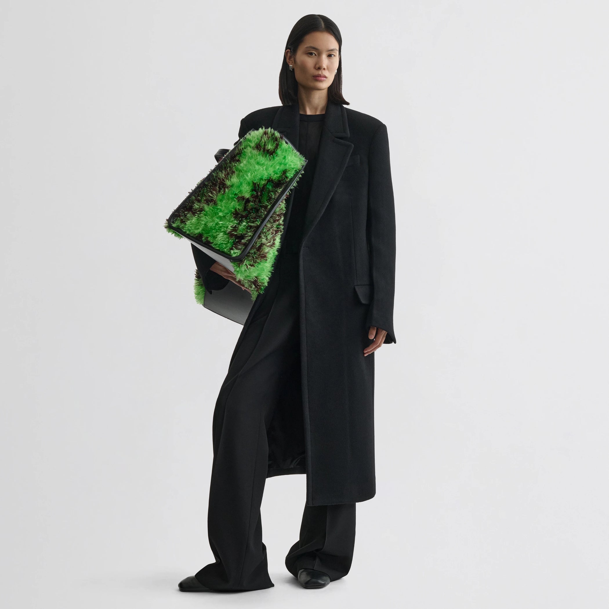 Front view of model wearing classic coat in black cashmere.