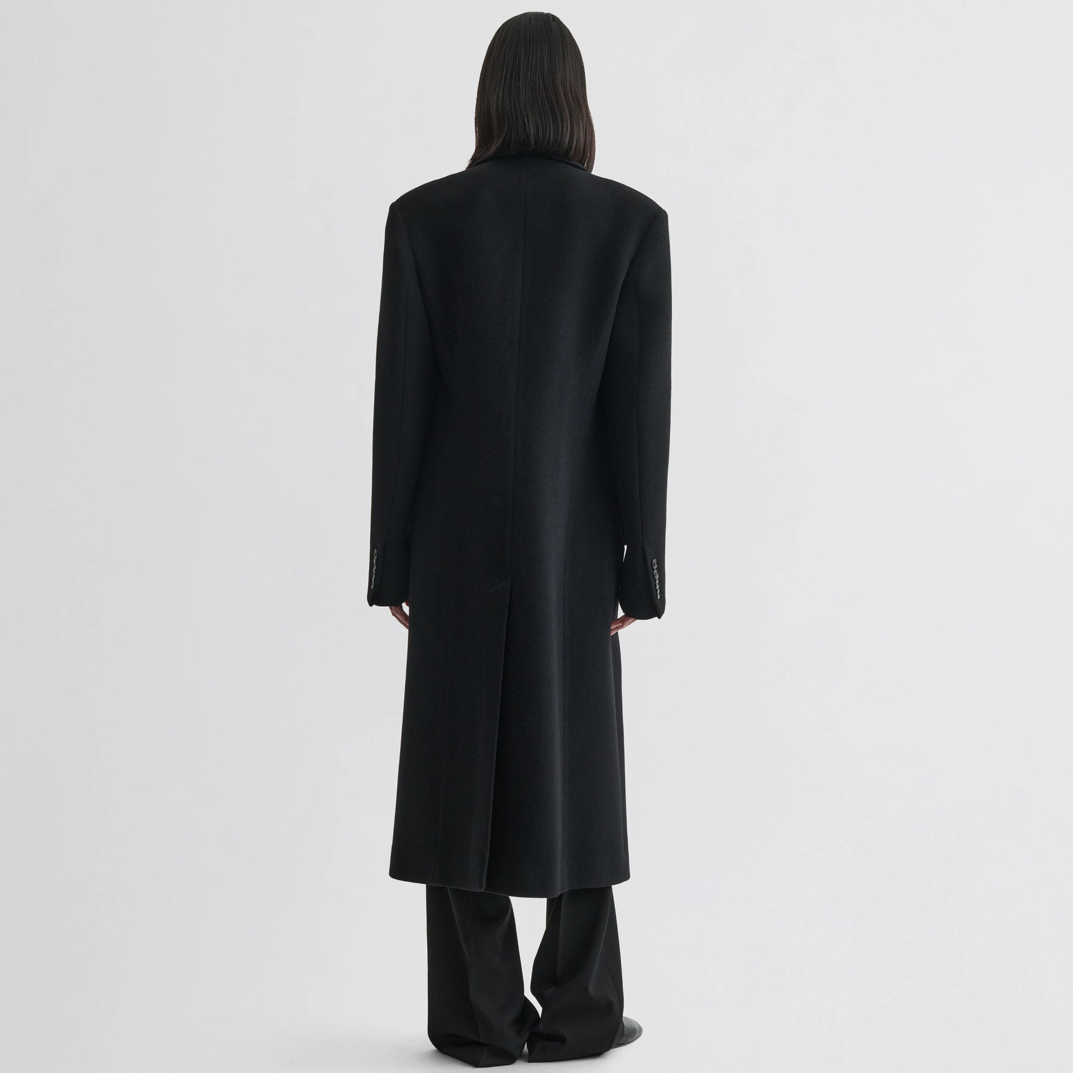 Back view of model wearing classic coat in black cashmere.