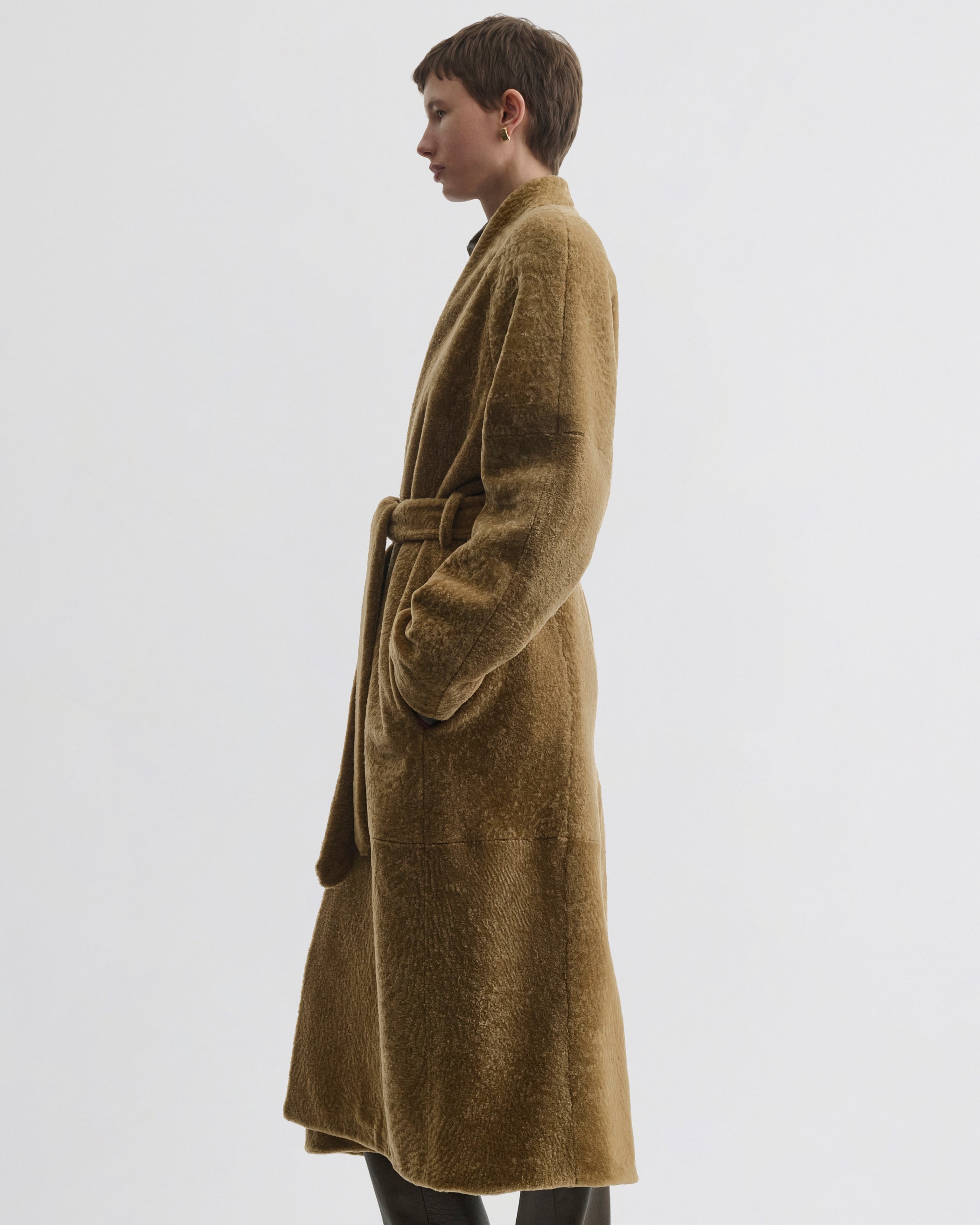 Side view of model wearing Shaved Robe Coat in tabac shearling