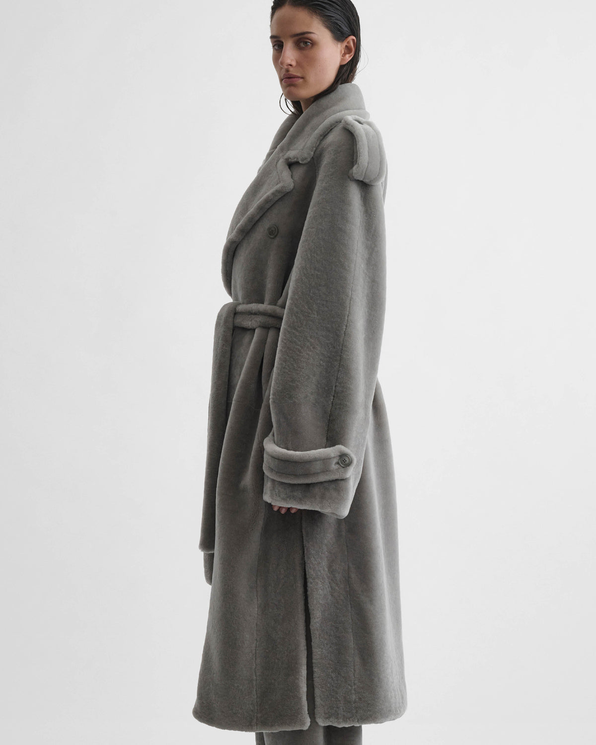 Side front view of model wearing TEDDY TRENCH COAT in grey shearling