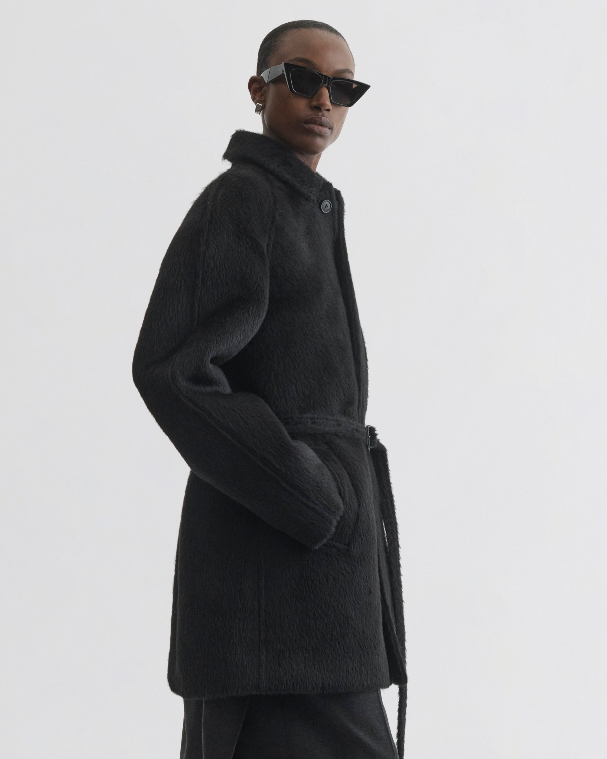 Side view of model wearing Cropped Car Coat in black alpaca wool