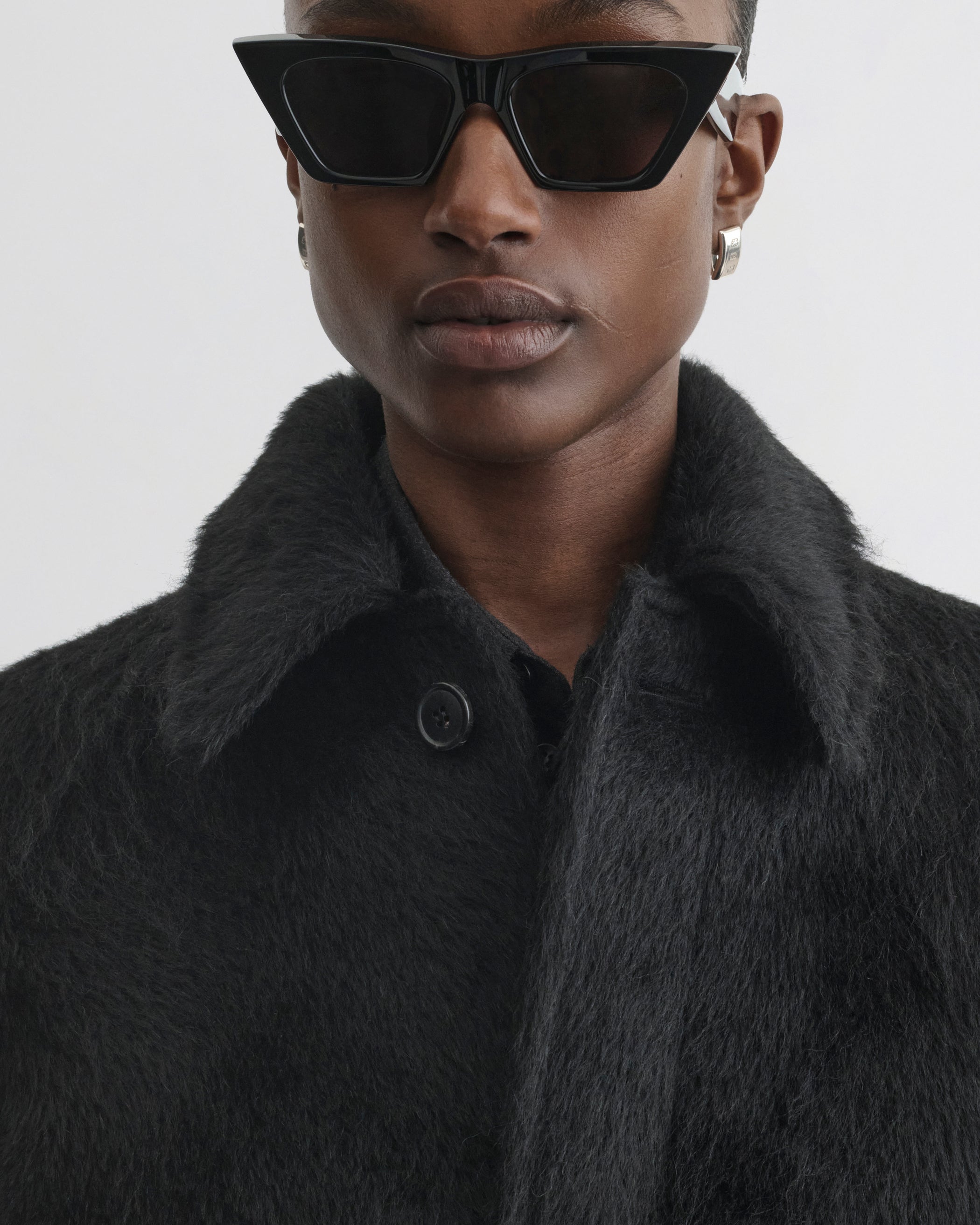Close up view of model wearing Cropped Car Coat in black alpaca wool