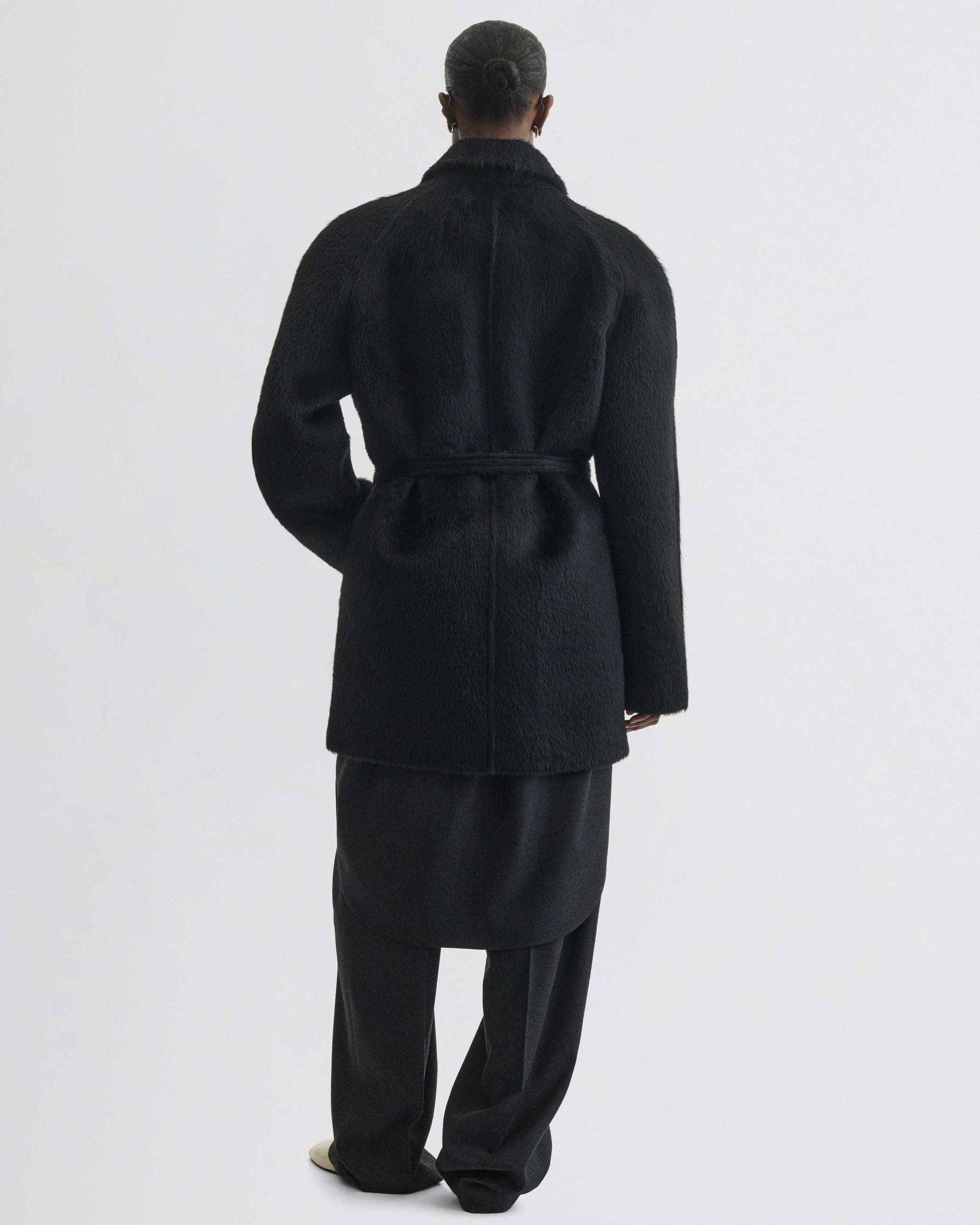 Back view of model wearing Cropped Car Coat in black alpaca wool