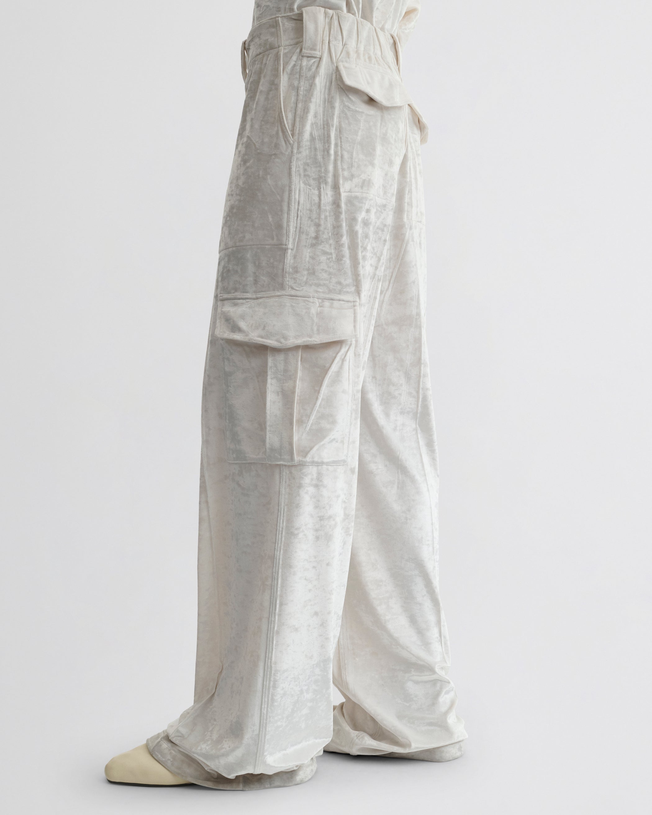 Side view of model wearing LIQUID CARGO TROUSERS  in white crushed velvet