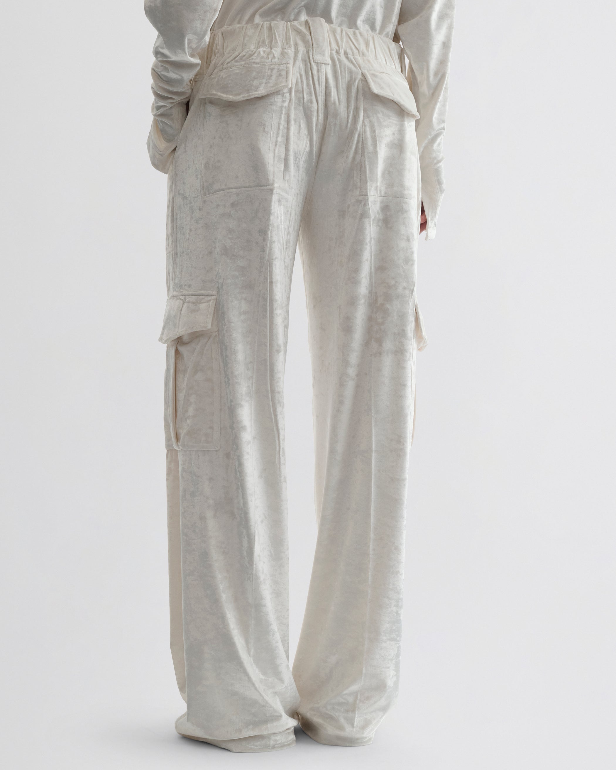 Back view of model wearing LIQUID CARGO TROUSERS  in white crushed velvet