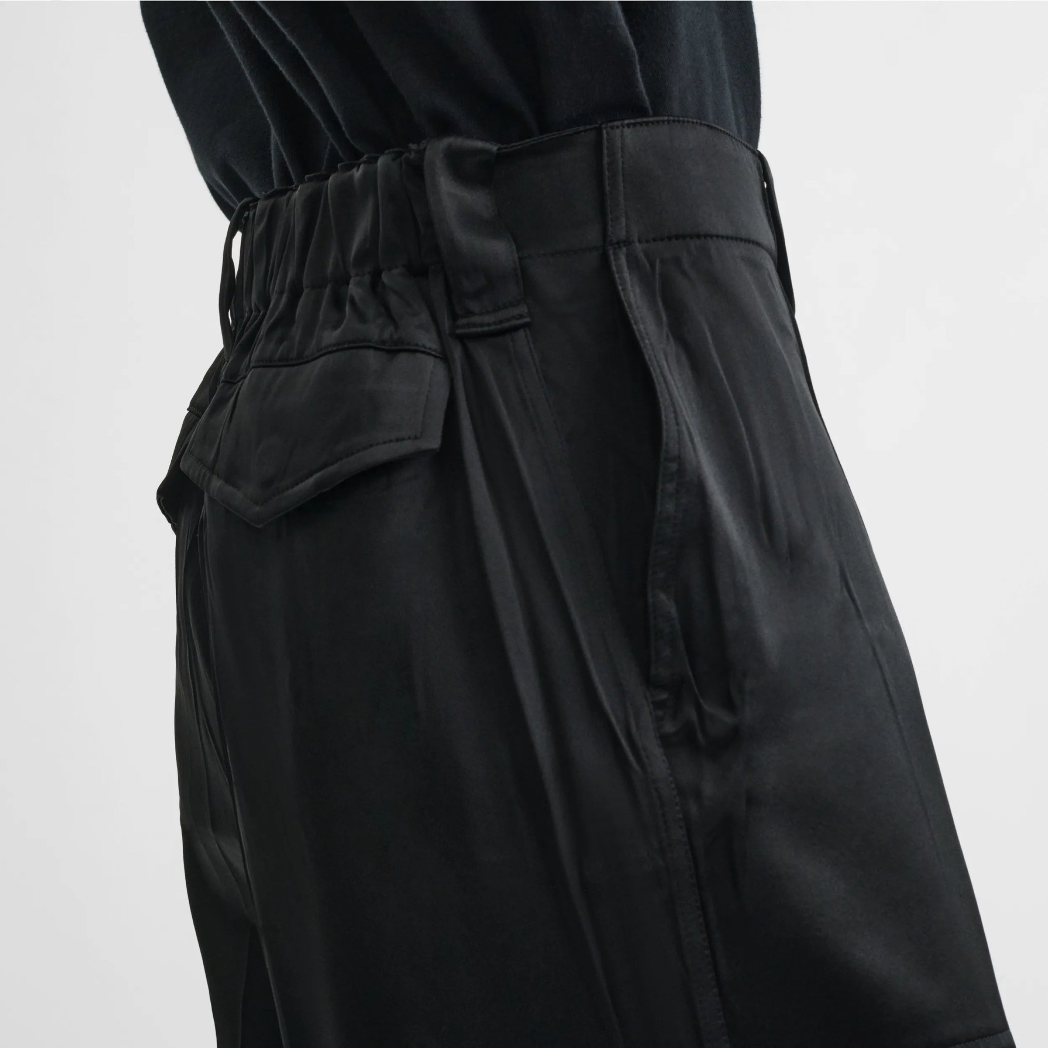 Close up detail view of liquid cargo trousers in black silk