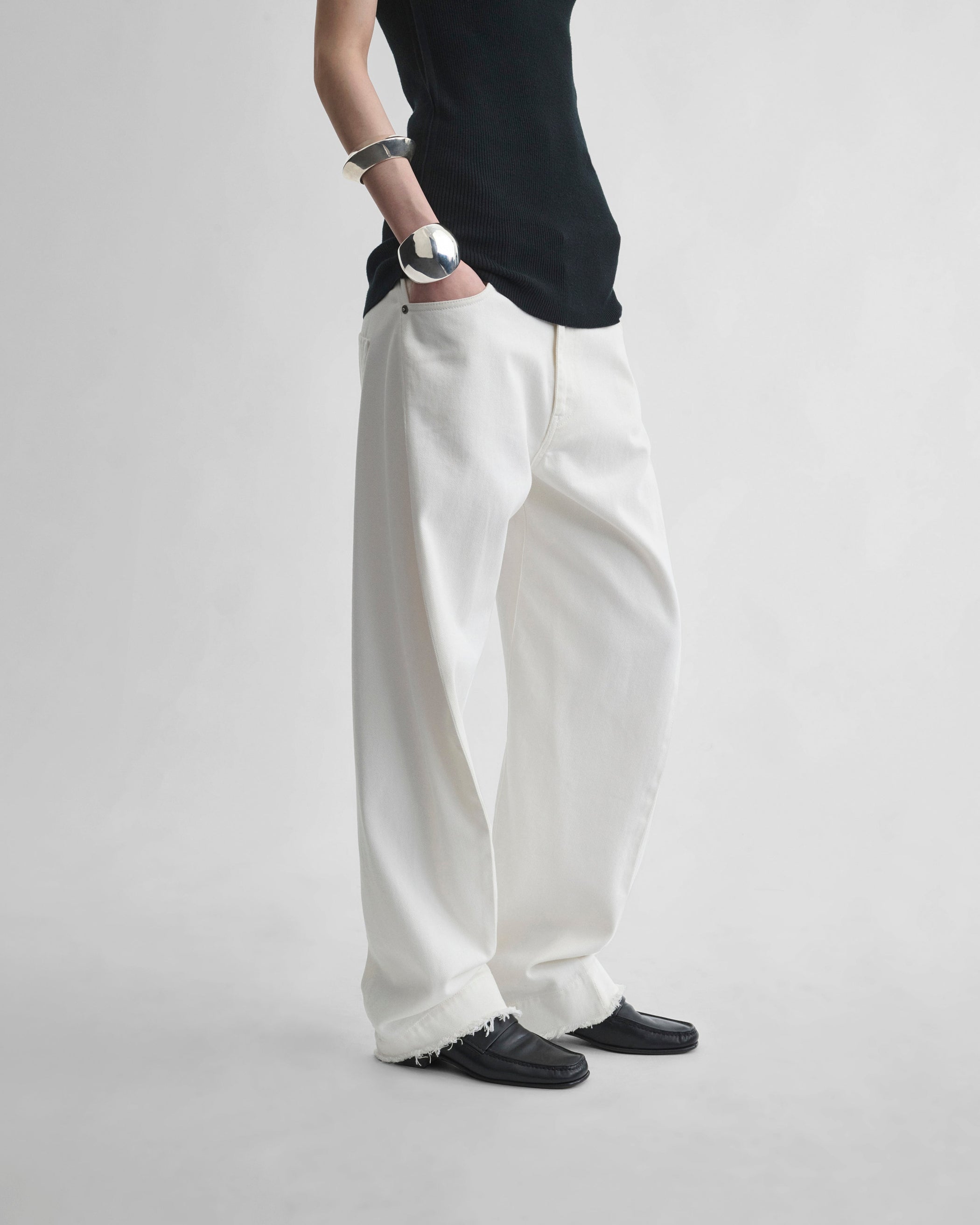 Side view of model wearing ARCH JEANS in off white cotton