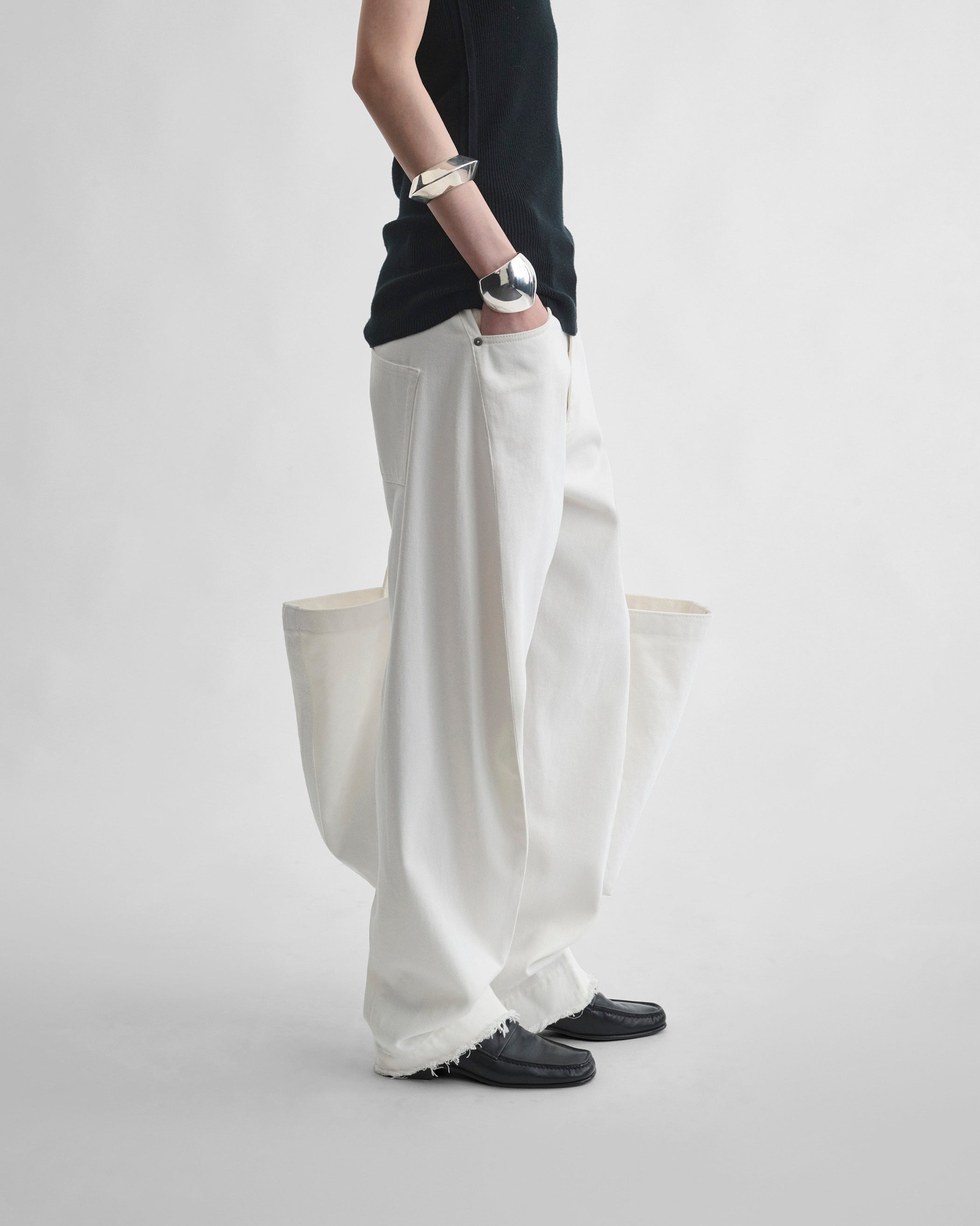 Side view of model wearing ARCH JEANS in off white cotton