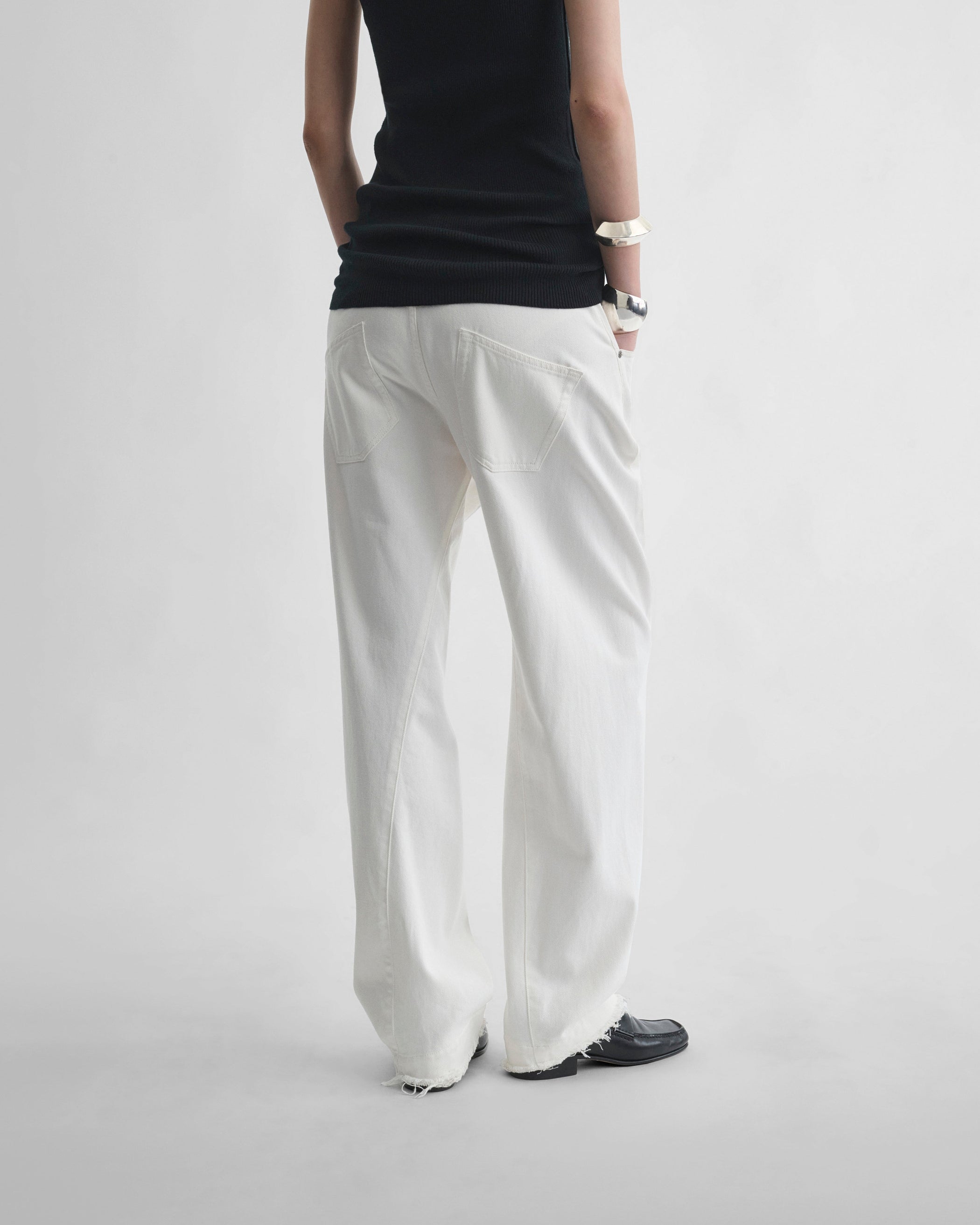 Back view of model wearing ARCH JEANS in off white cotton