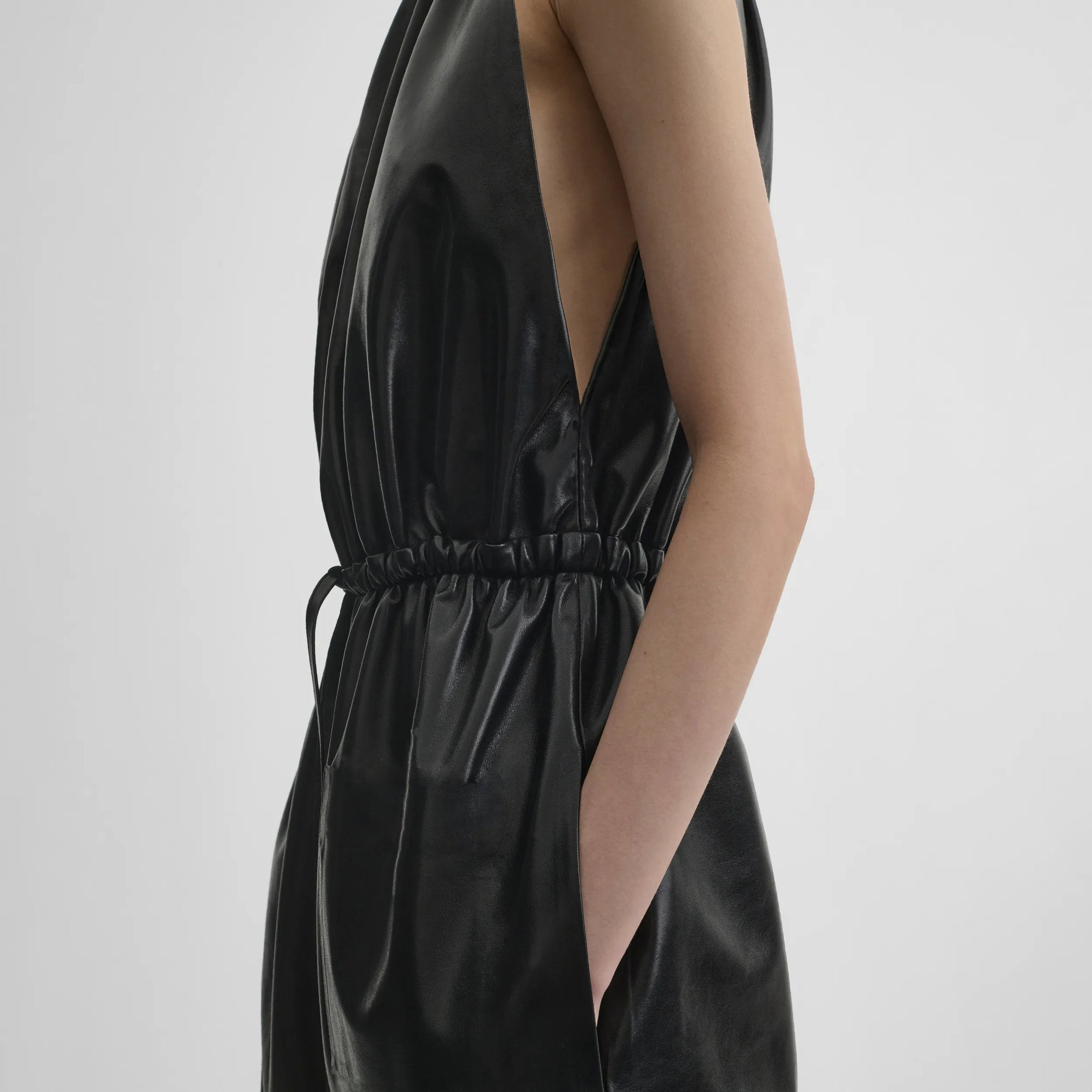 Close up detail view of drawstring jumpsuit in black leather.