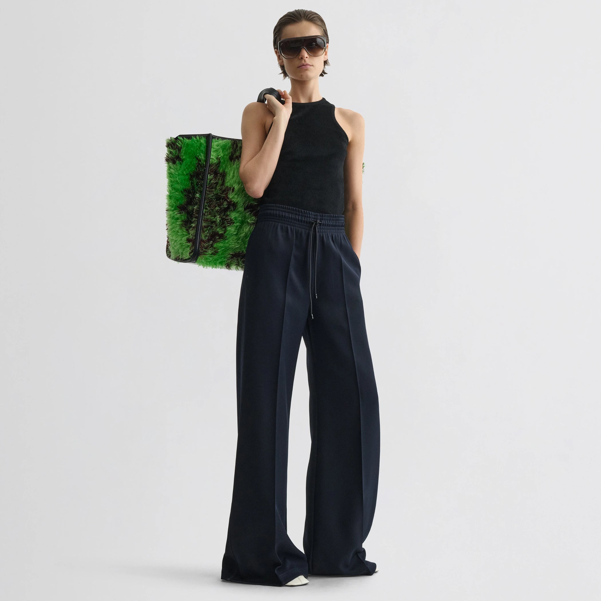 Front view of model wearing track trousers in navy polyester.