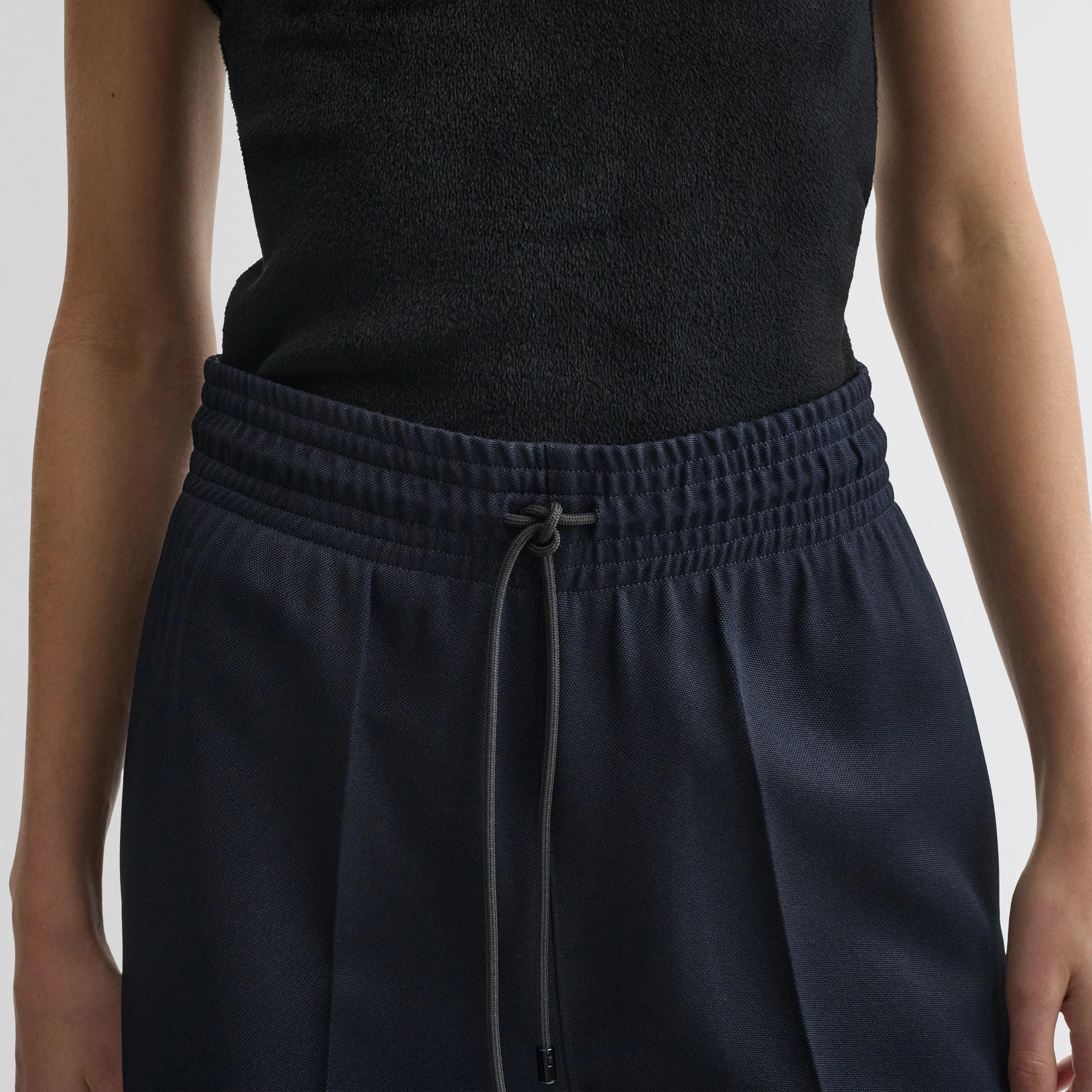 Close up detail view of track trousers in navy polyester.