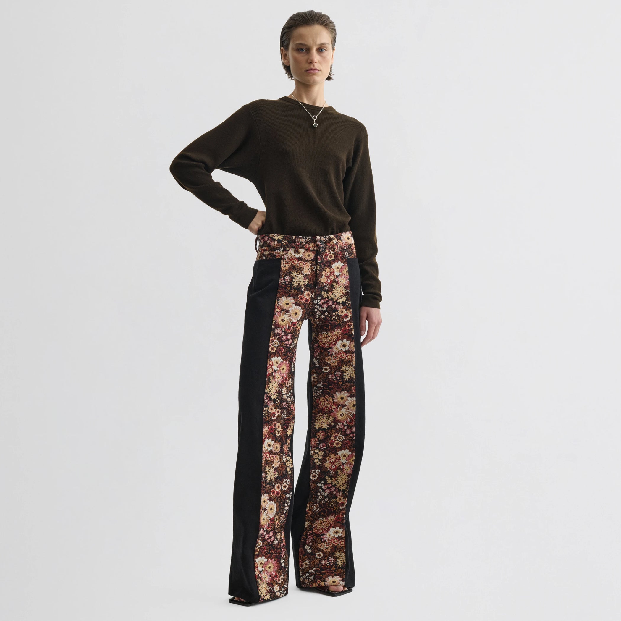 Front view of model wearing tapestry trousers in black cotton.