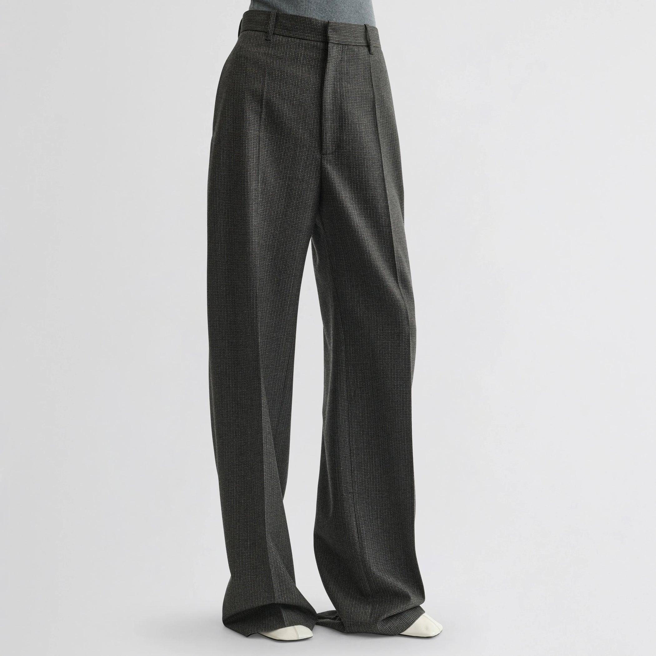 Front view of model wearing zip trousers in green bronze wool.