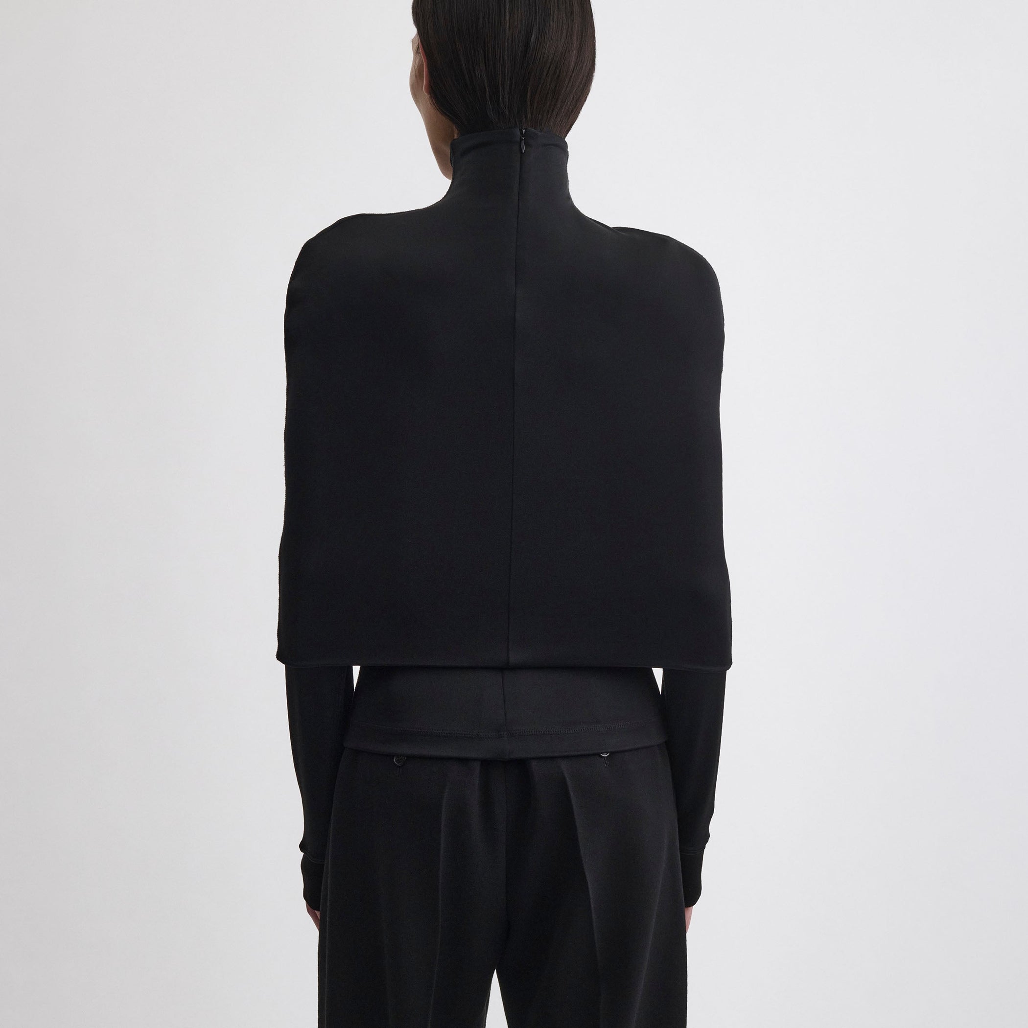 Back view of model wearing CAPE TOP in black viscose