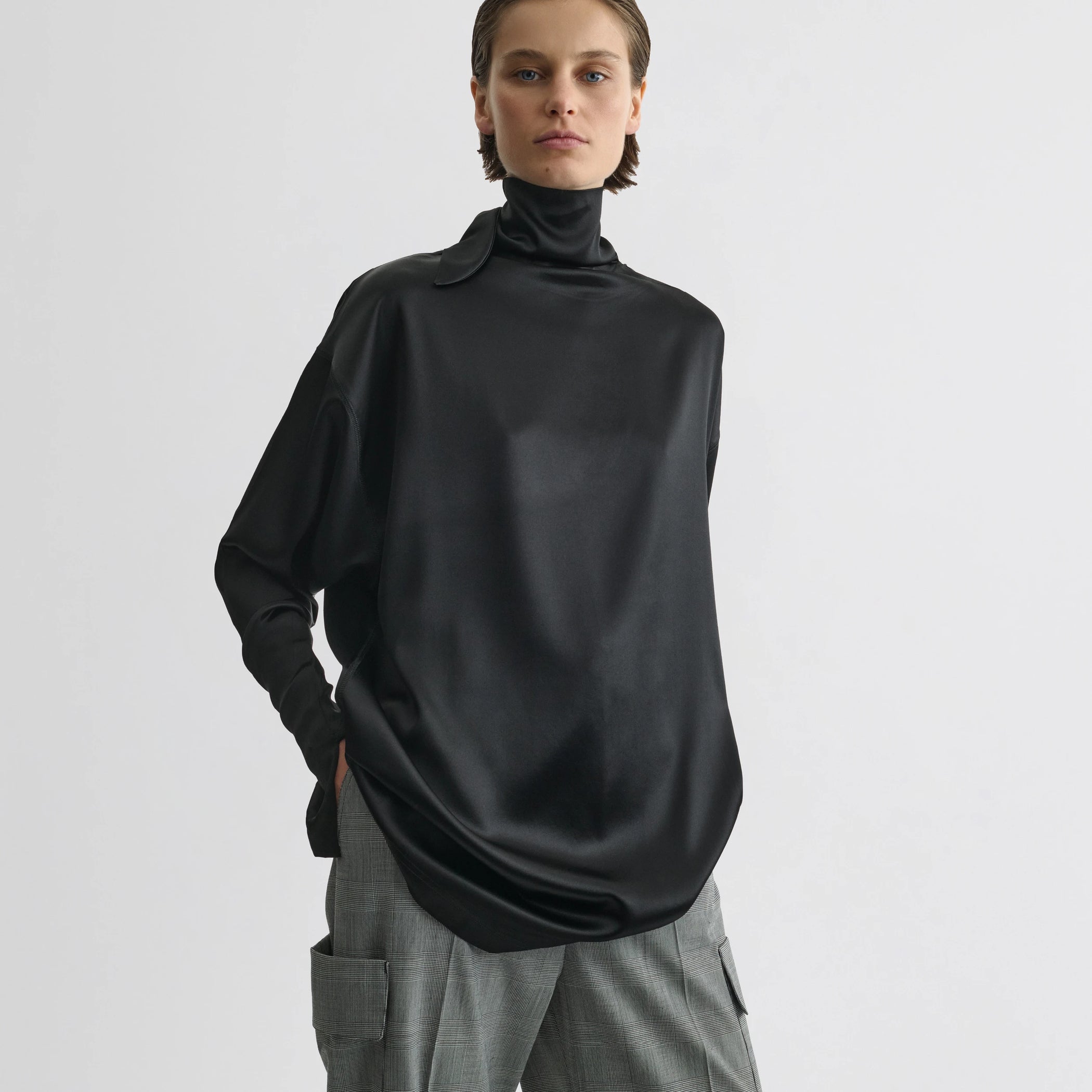 Front view of model wearing liquid knot collar top in black silk.