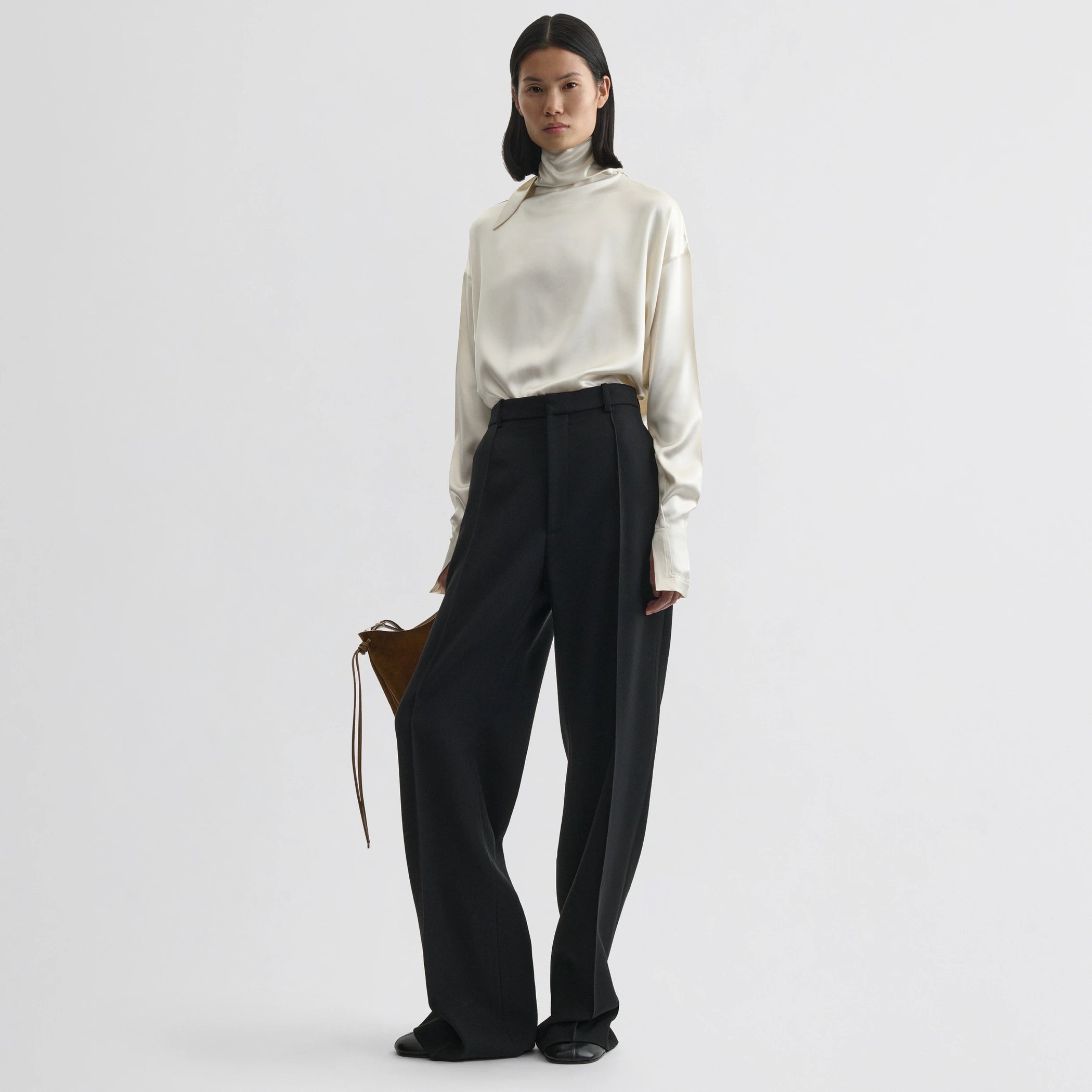 Front view of model wearing liquid knot collar top in cream silk.