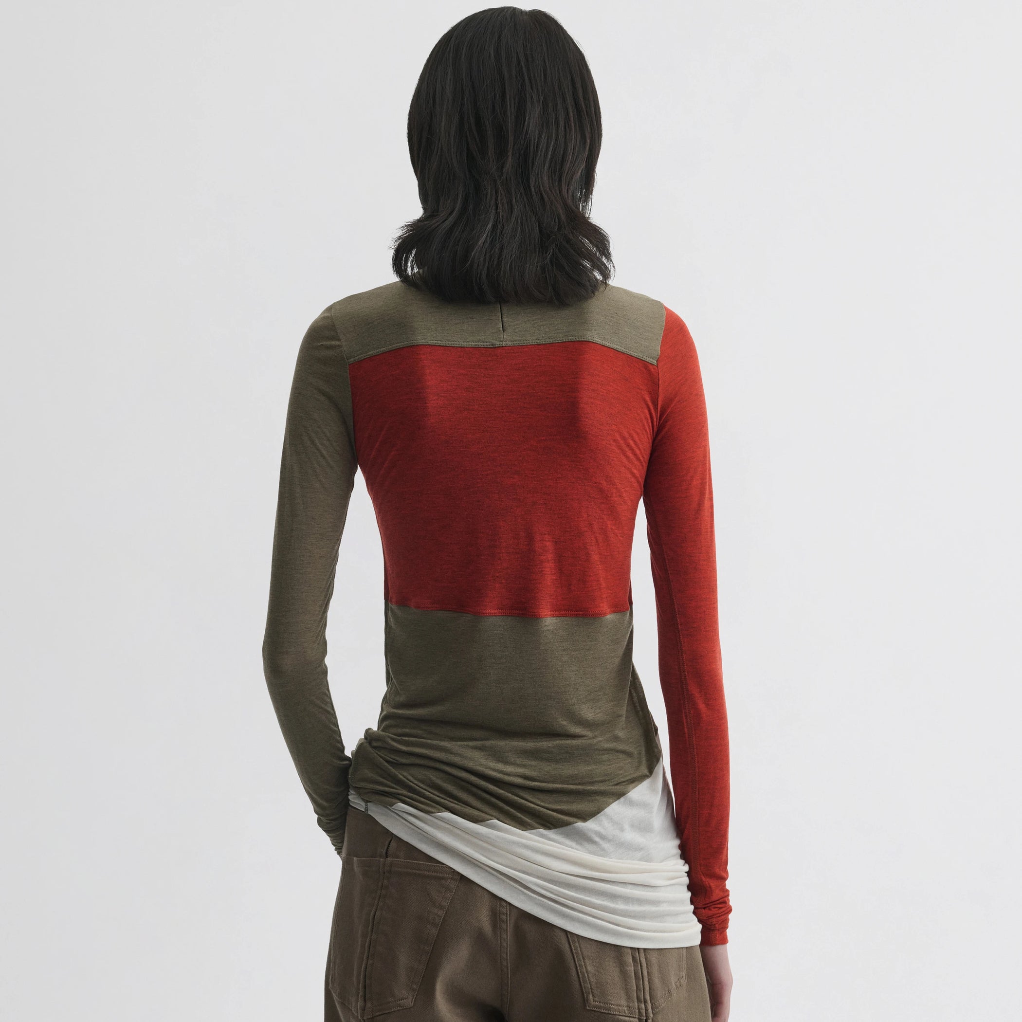 Back view of model wearing tubular colour block top in ivory tobacco red cotton.