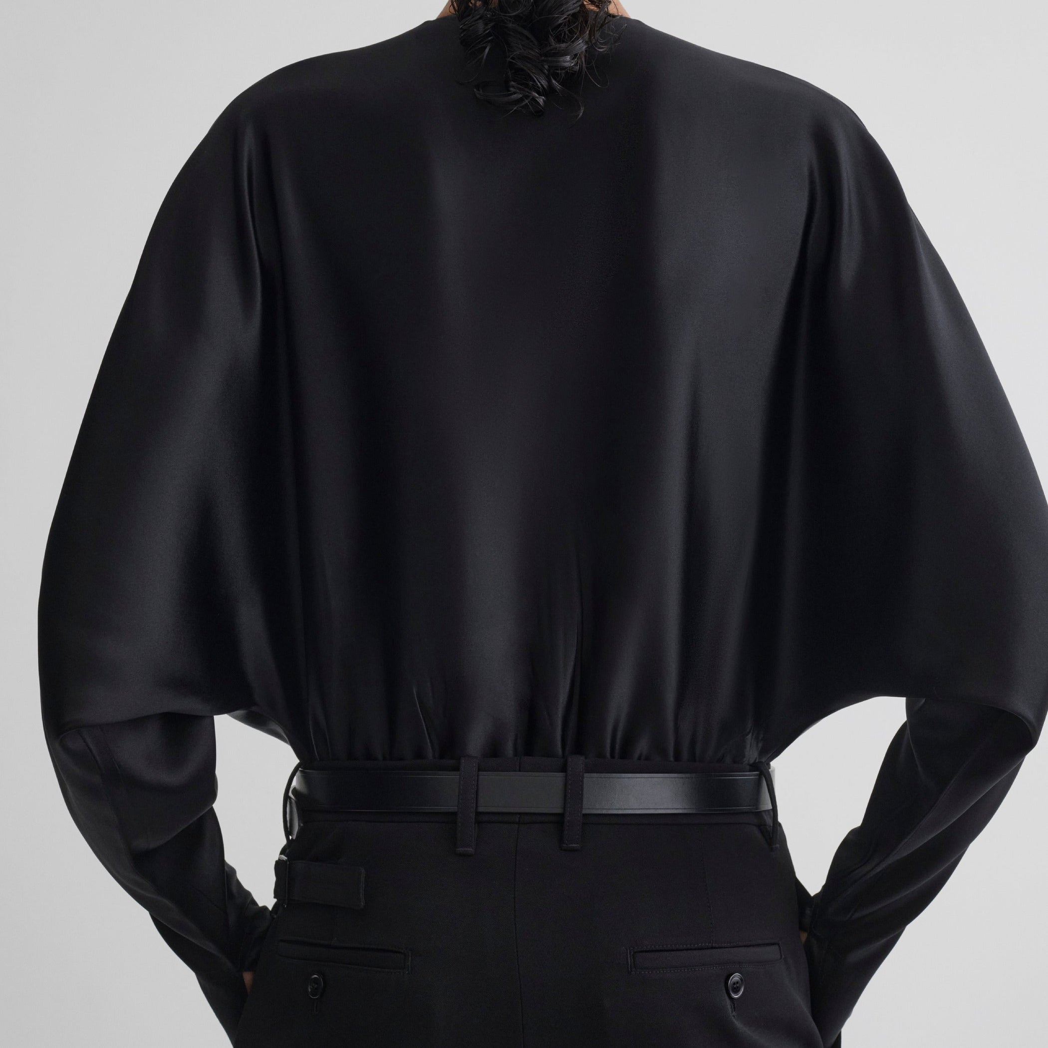 Back view of model wearing BATWING BODY in black silk satin