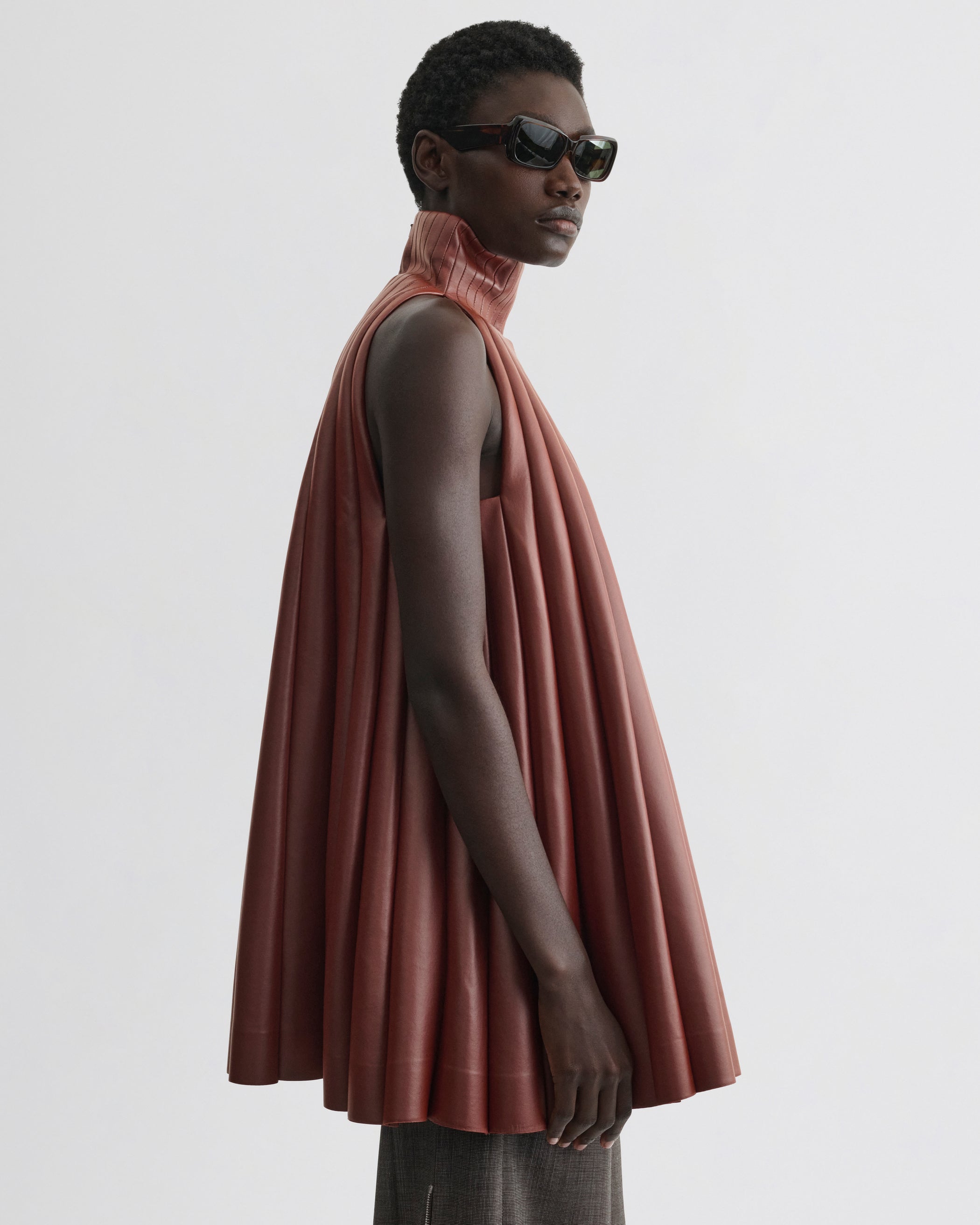 Side view of model wearing Accordion Top in brick bonded jersey