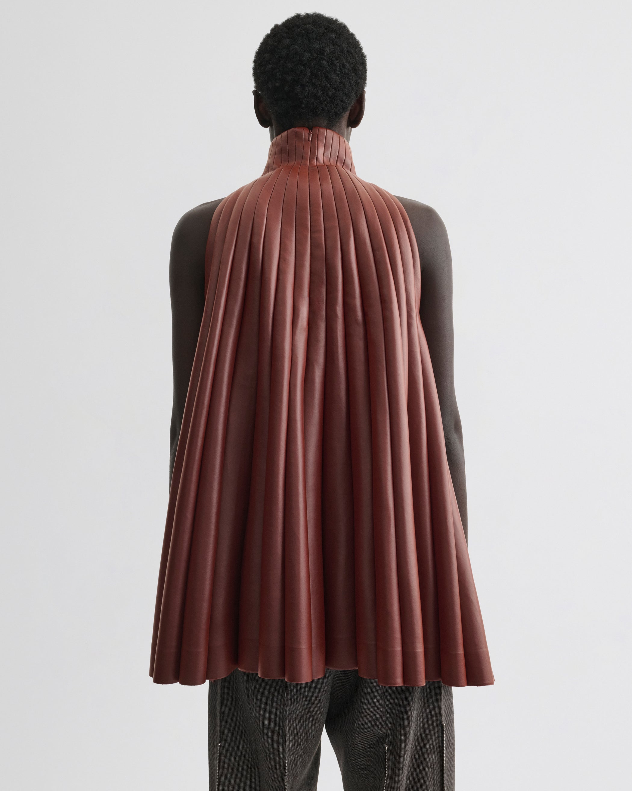 Back view of model wearing Accordion Top in brick bonded jersey