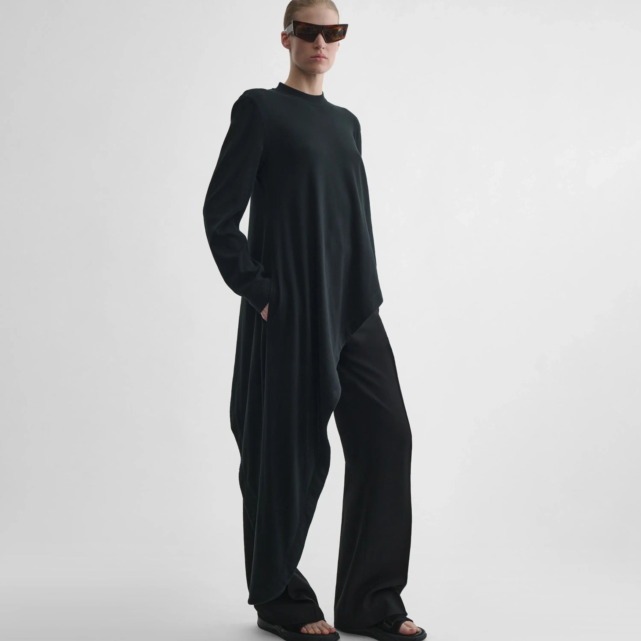 Full body front view of model wearing Asymmetric T-shirt Top in black.