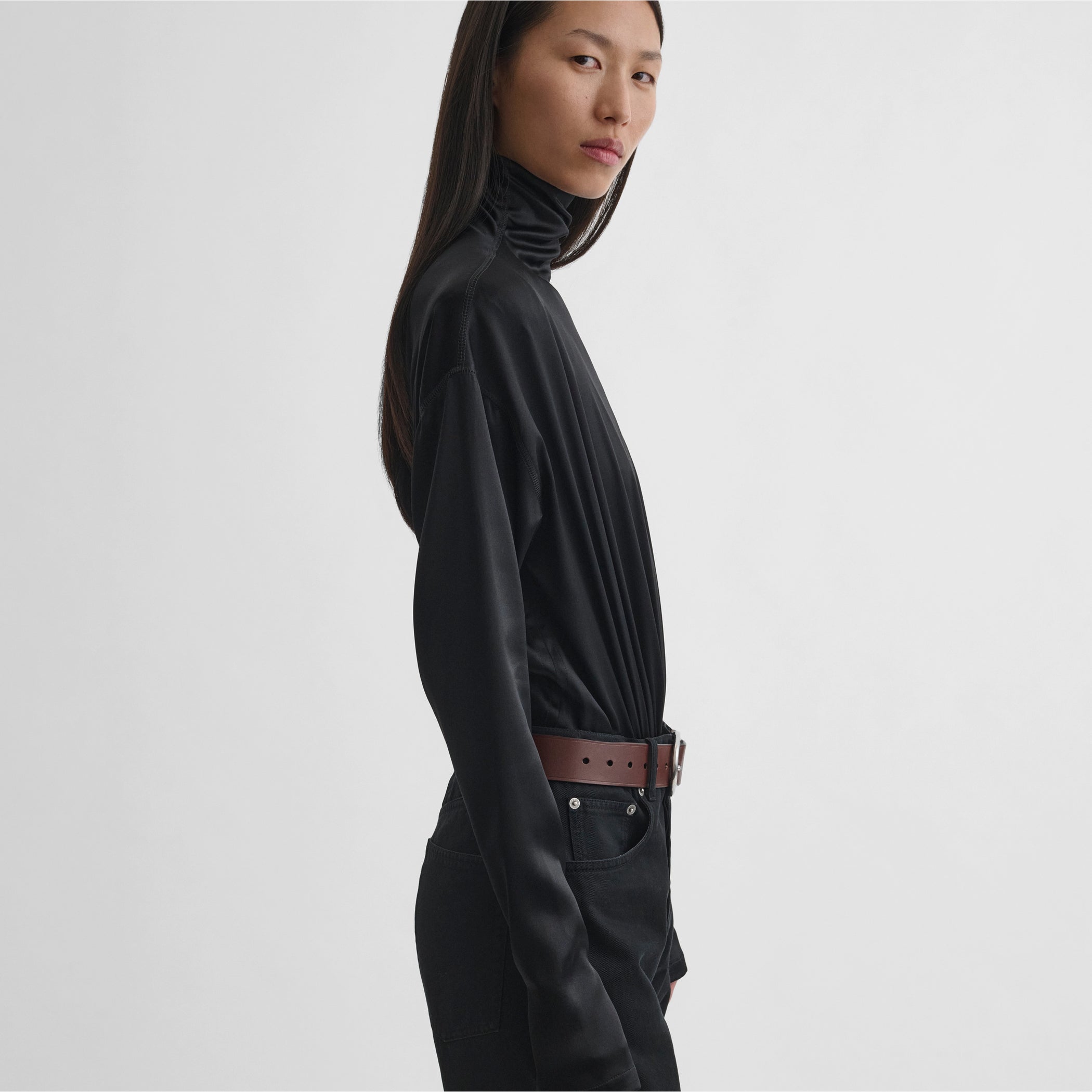Side view of model wearing sharp shoulder body in black silk satin 
