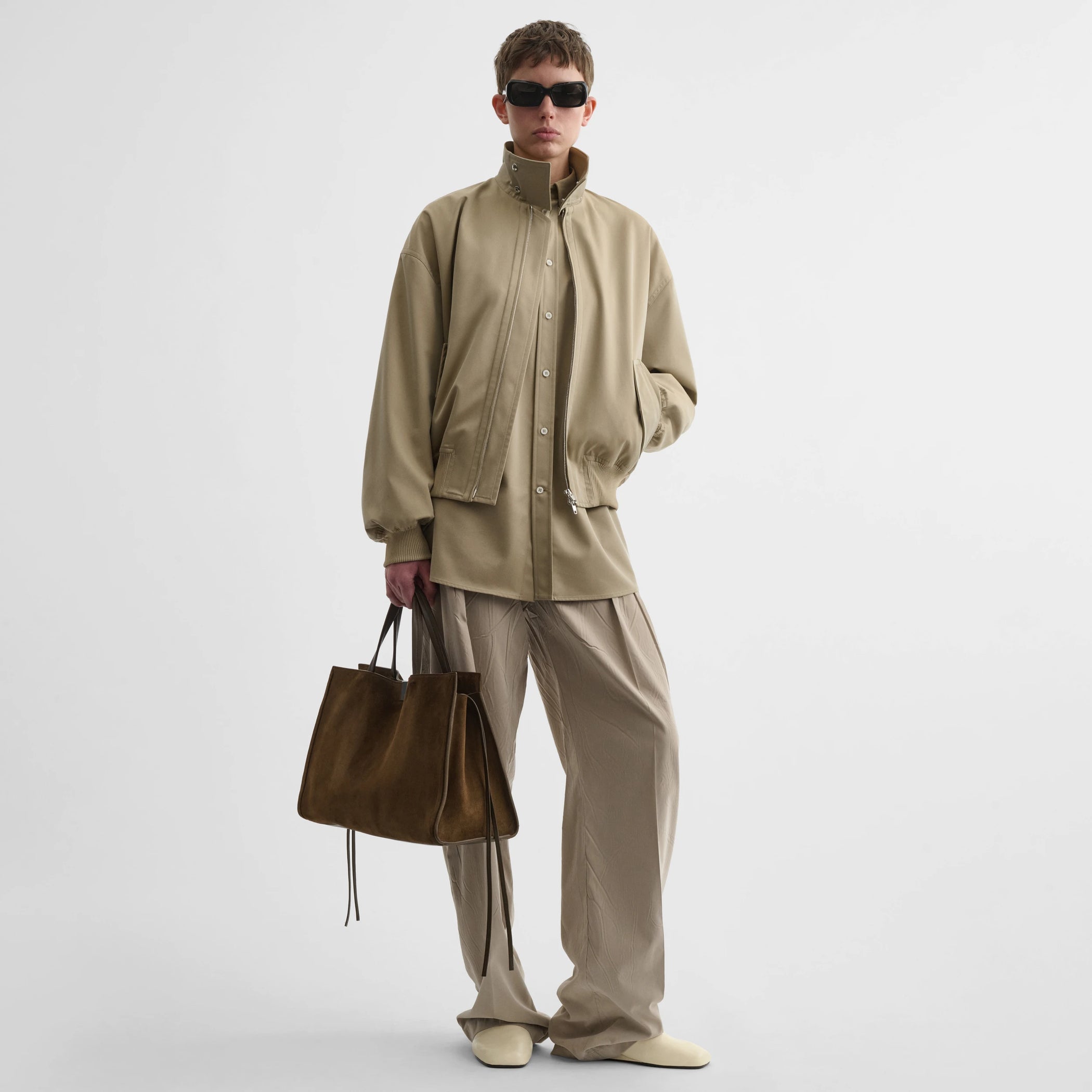 Front view of model wearing golf jacket in trench cotton.