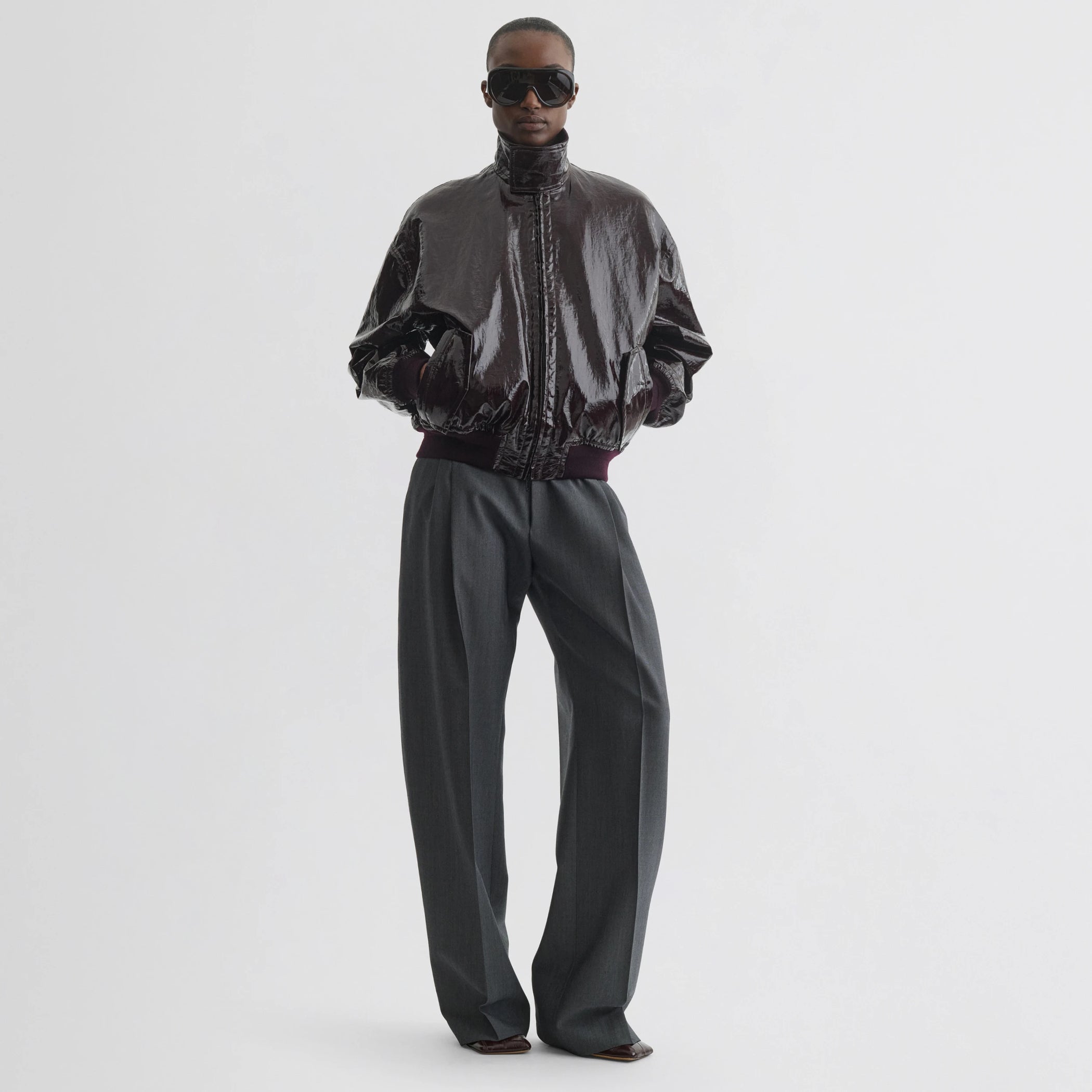 Front view of model wearing golf jacket in burgundy linen canvas.