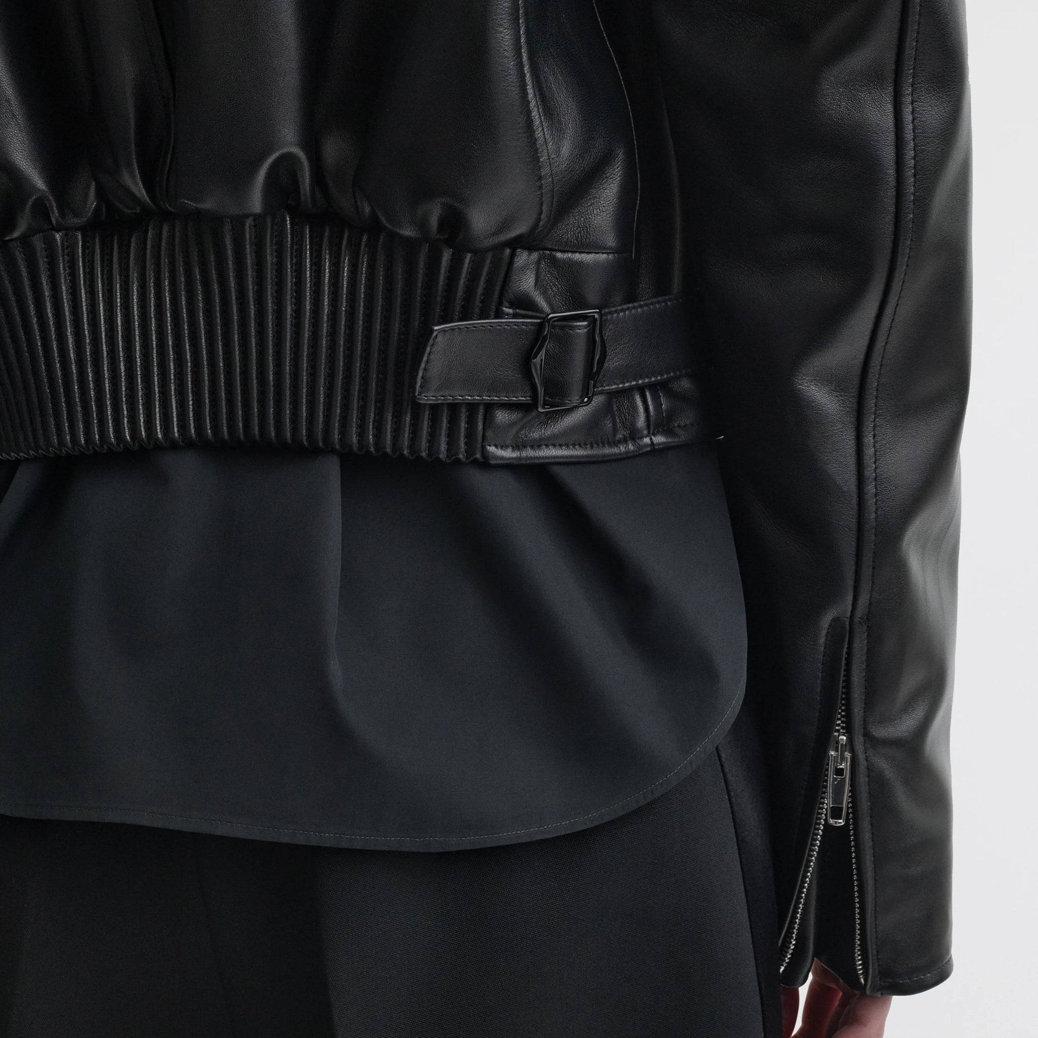 Close up detail view of cropped aviator jacket in black leather.