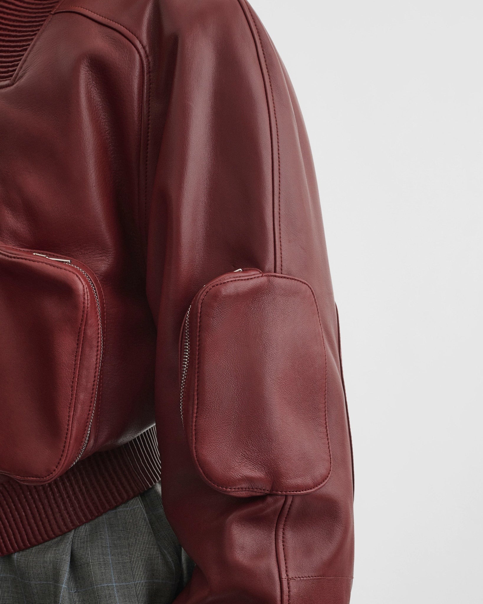 Close up detail view of pocket bomber jacket in brick leather