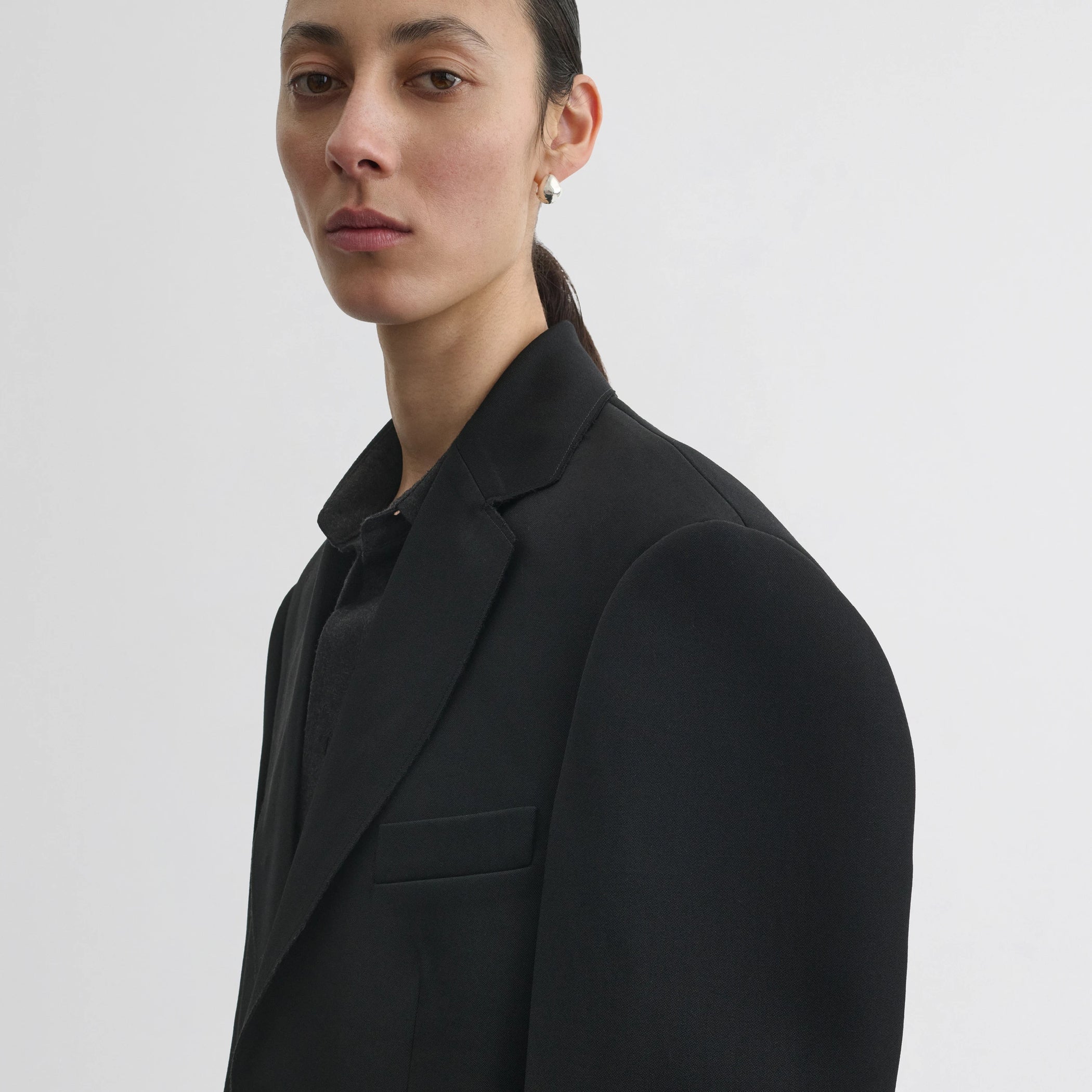 Close up detail view of tuxedo jacket in black wool.