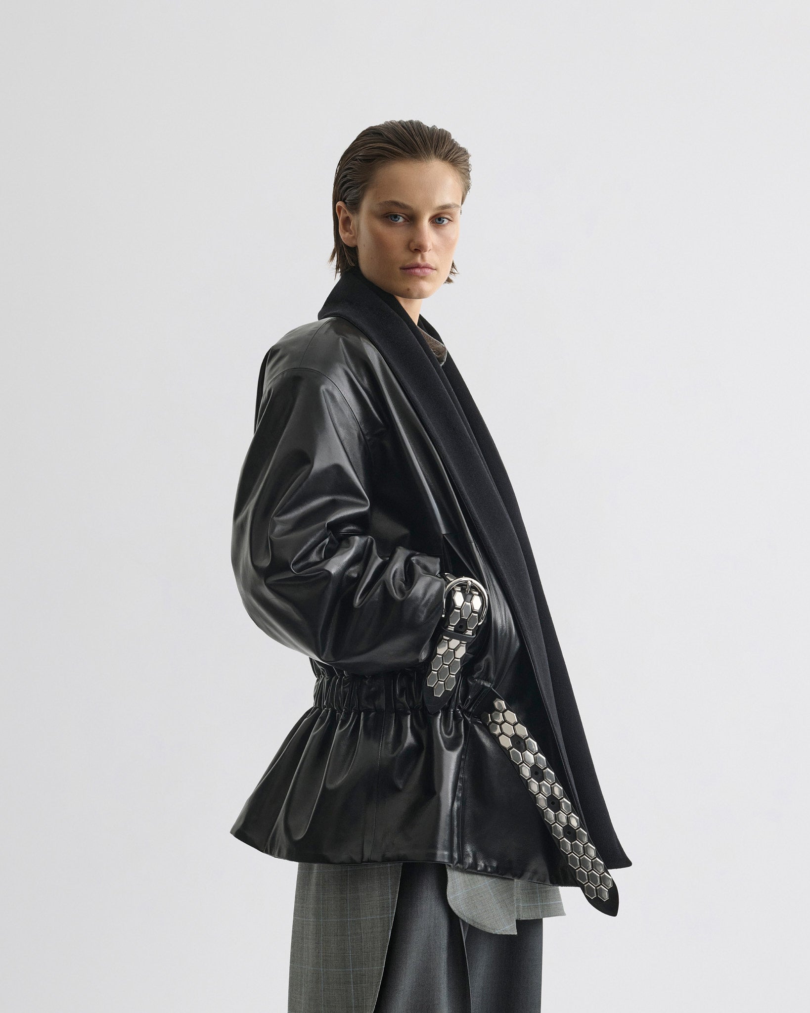 Side view of model wearing Stud Jacket in black leather