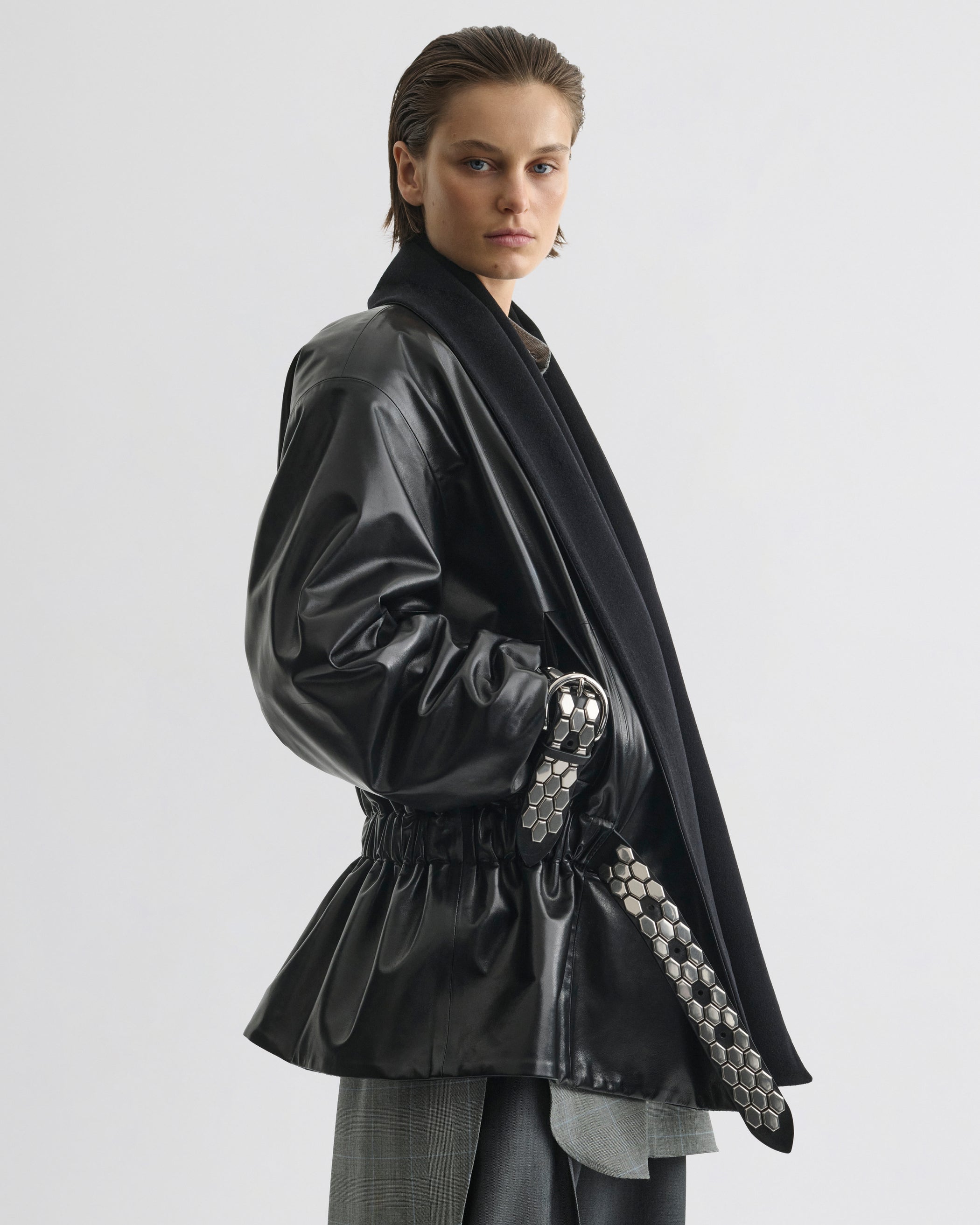 Side view of model wearing Stud Jacket in black leather