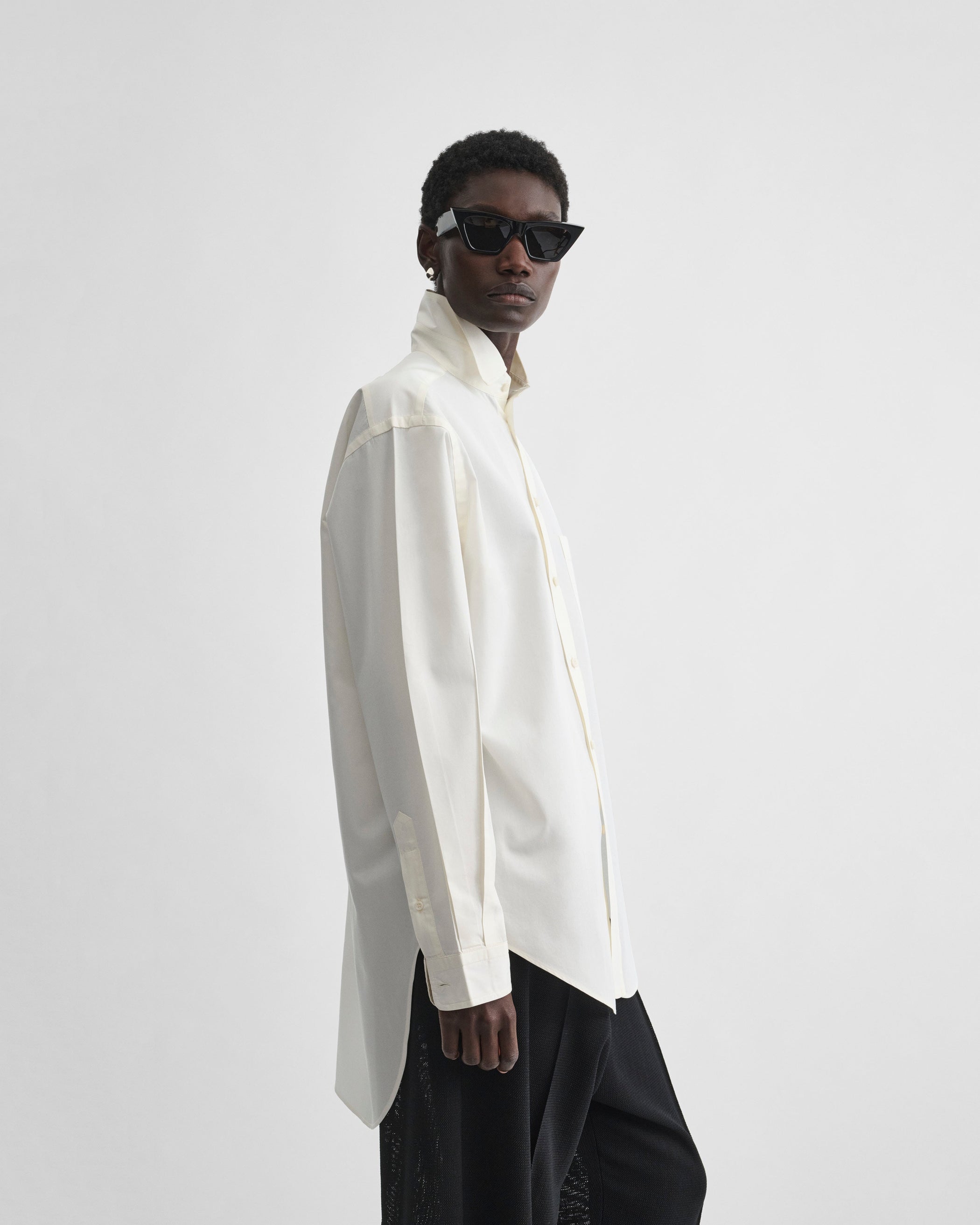 Side view of model wearing CLASSIC SHIRT in cream cotton