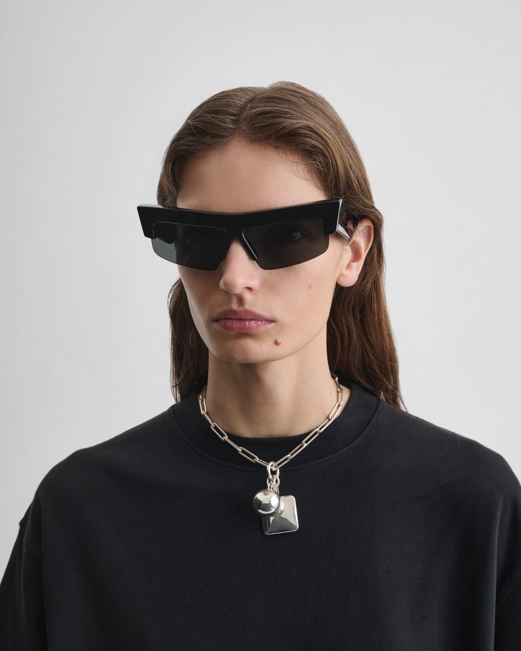 Front view of model wearing SLICED CRUISE SUNGLASSES in black acetate