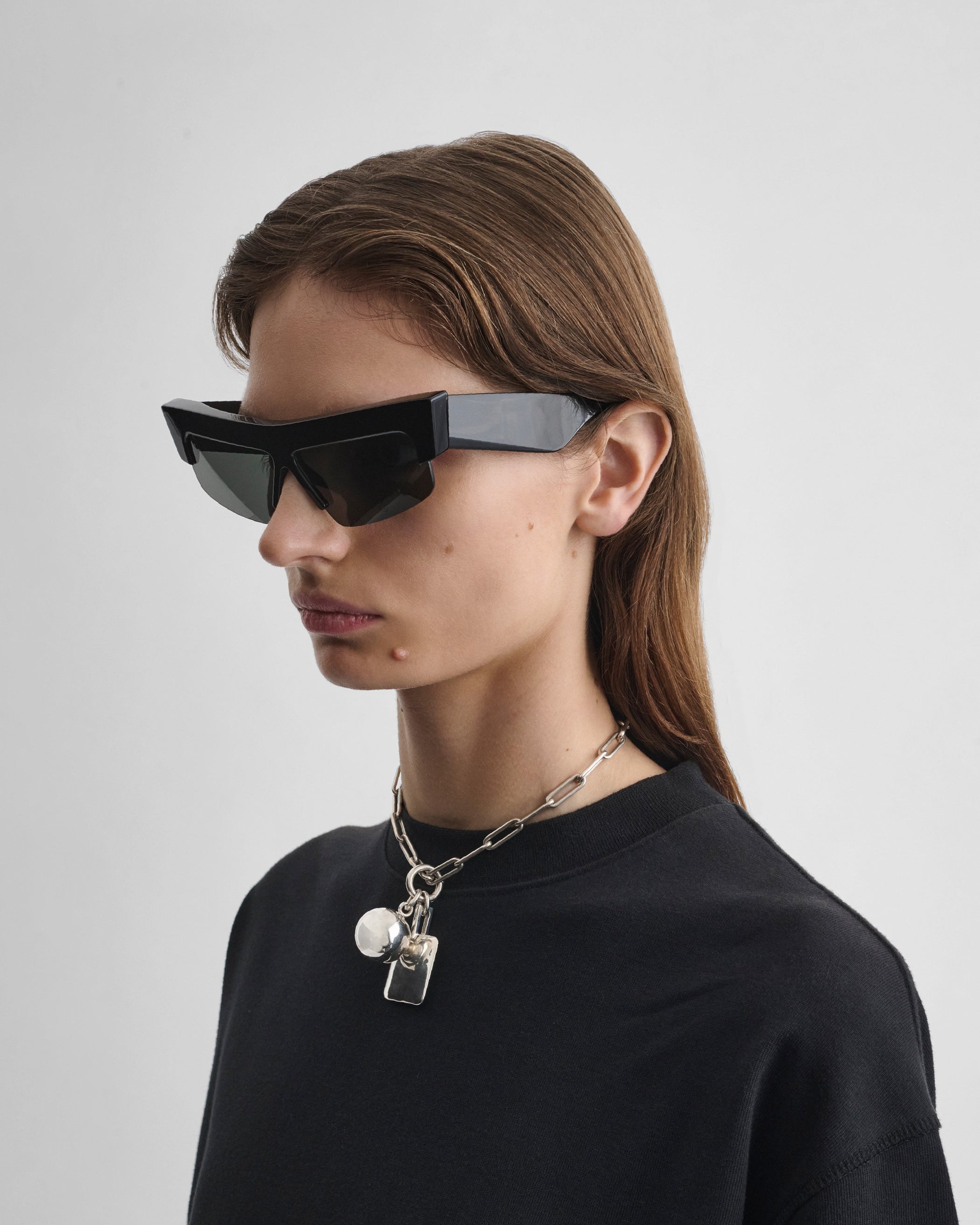 Side view of model wearing SLICED CRUISE SUNGLASSES in black acetate