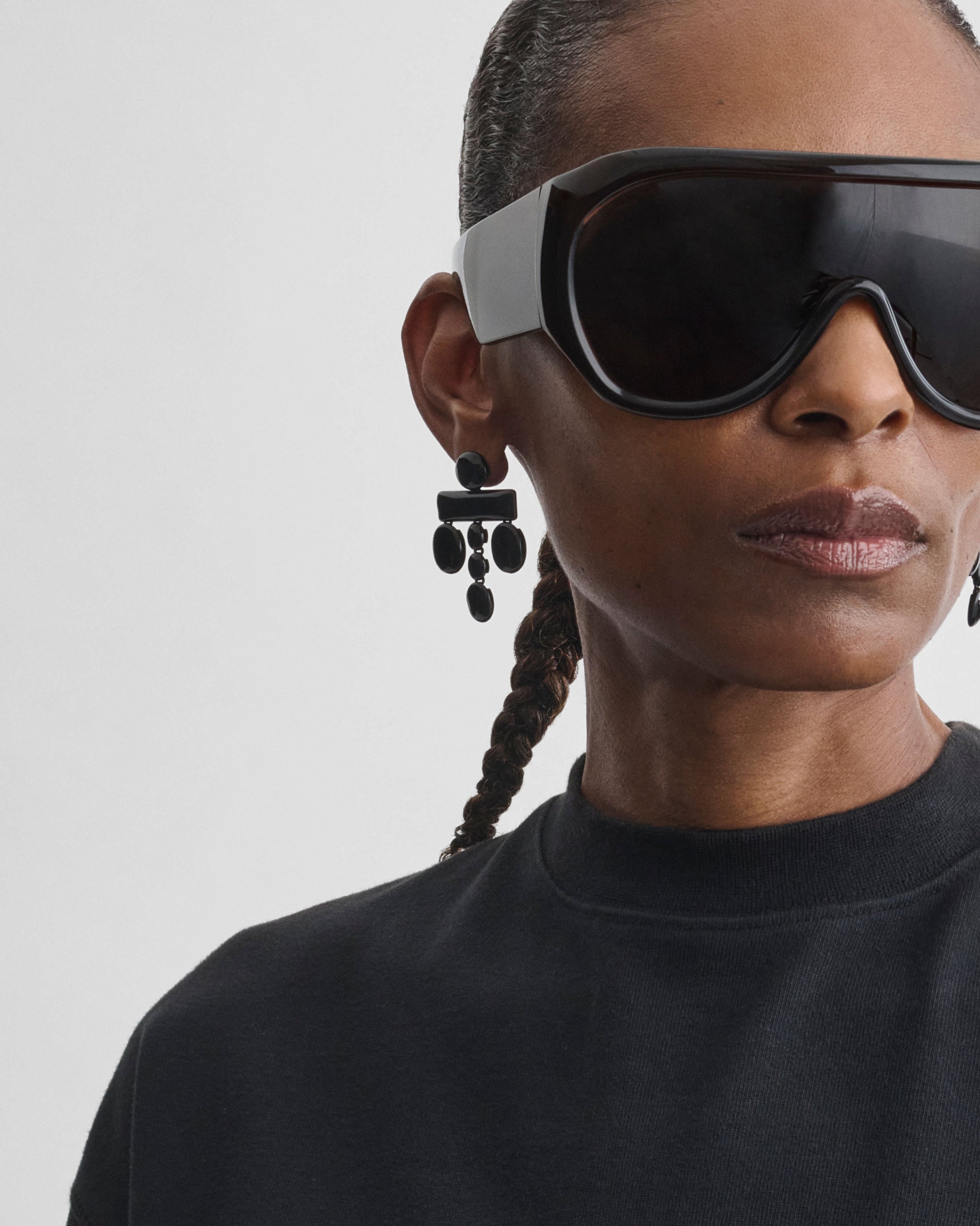 Front view of model wearing DROPLET CHANDELIER EARRINGS in black