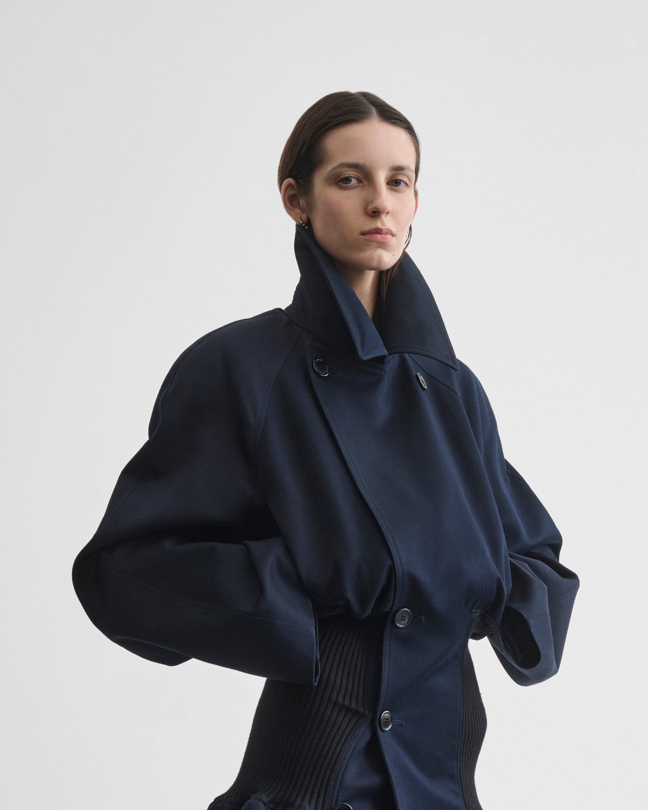 Front view of model wearing KICK COAT in dark navy cotton