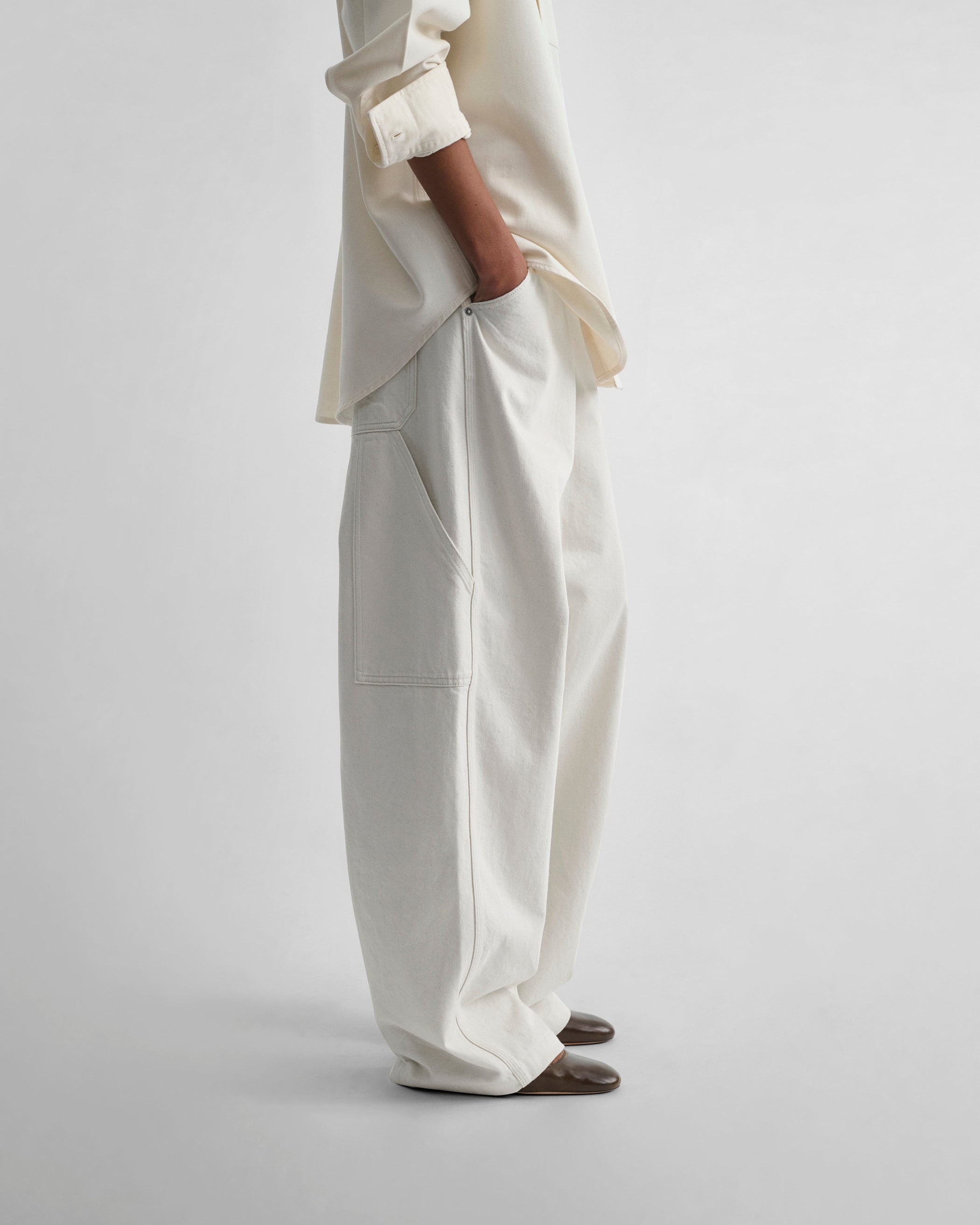 Side view of model wearing UTILITY JEANS in chalk cotton