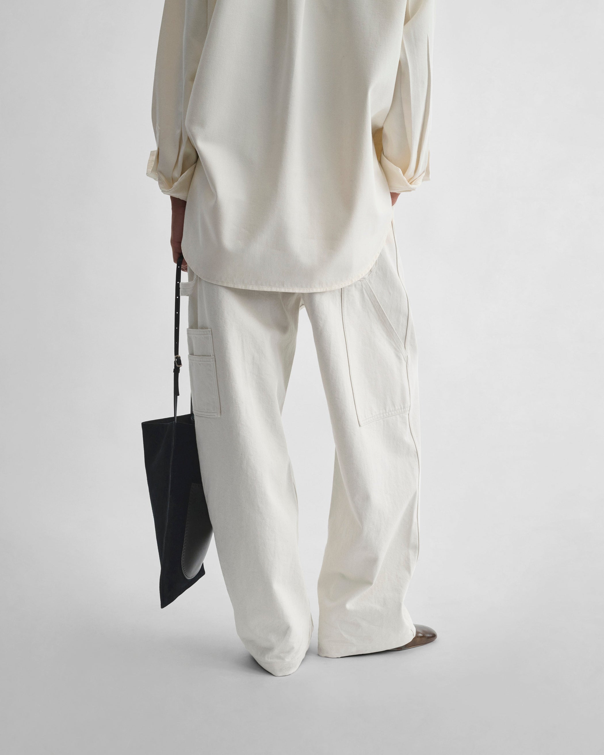 Back view of model wearing UTILITY JEANS in chalk cotton