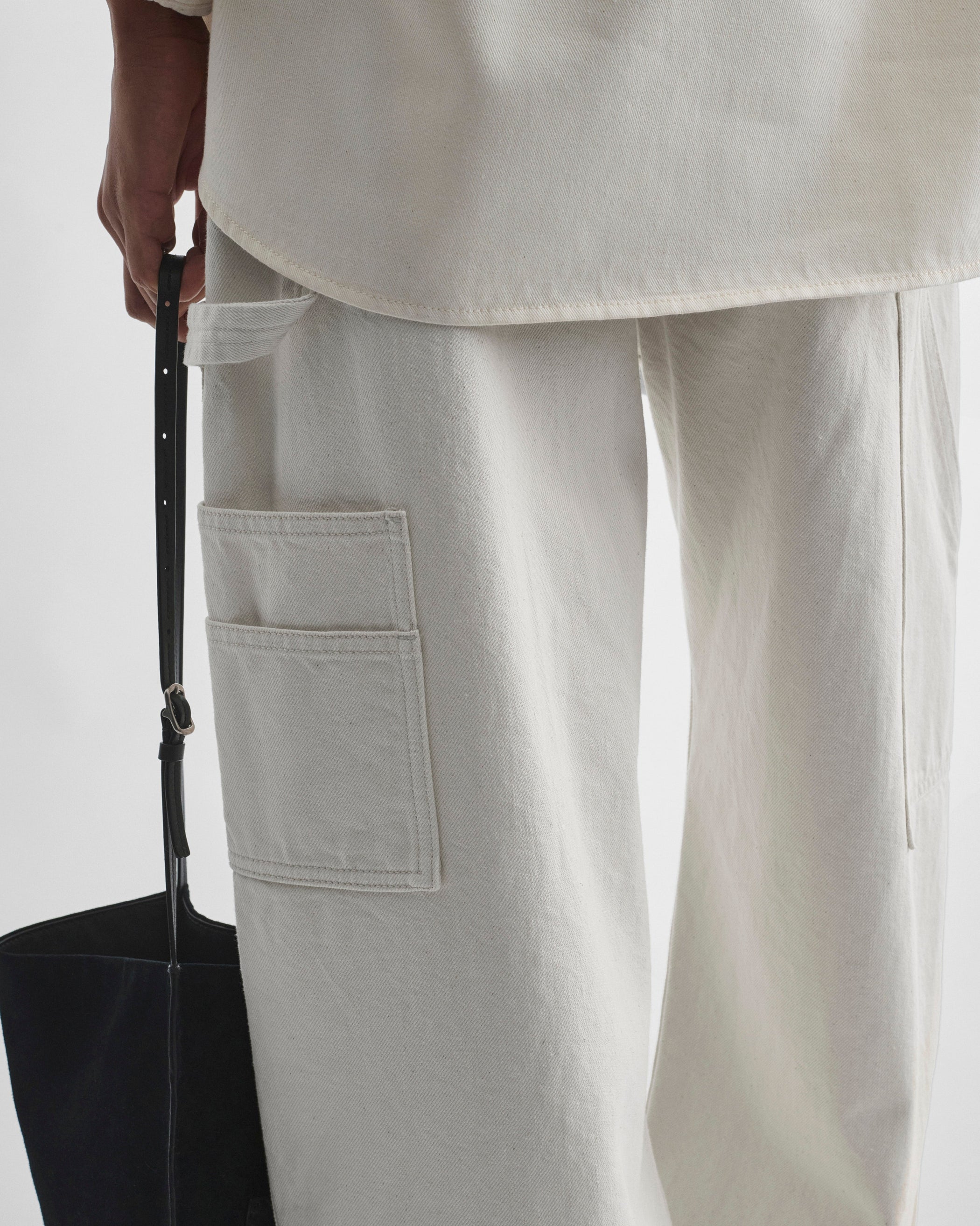 Detail view of model wearing UTILITY JEANS in chalk cotton