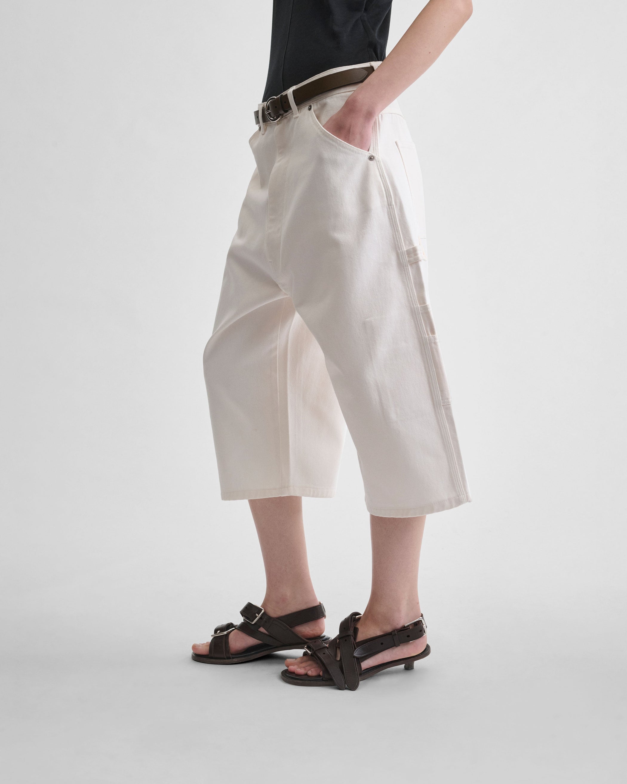 Side view of model wearing CARPENTER SHORTS in pale blush