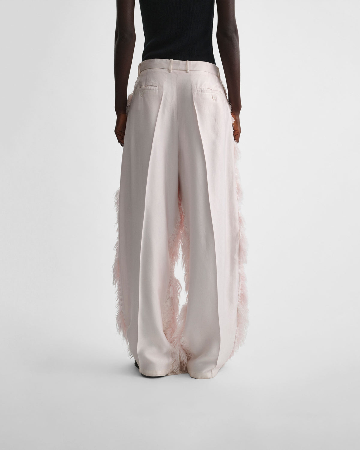 Back view of model wearing COMBED EMBROIDERED TROUSERS in floss viscose